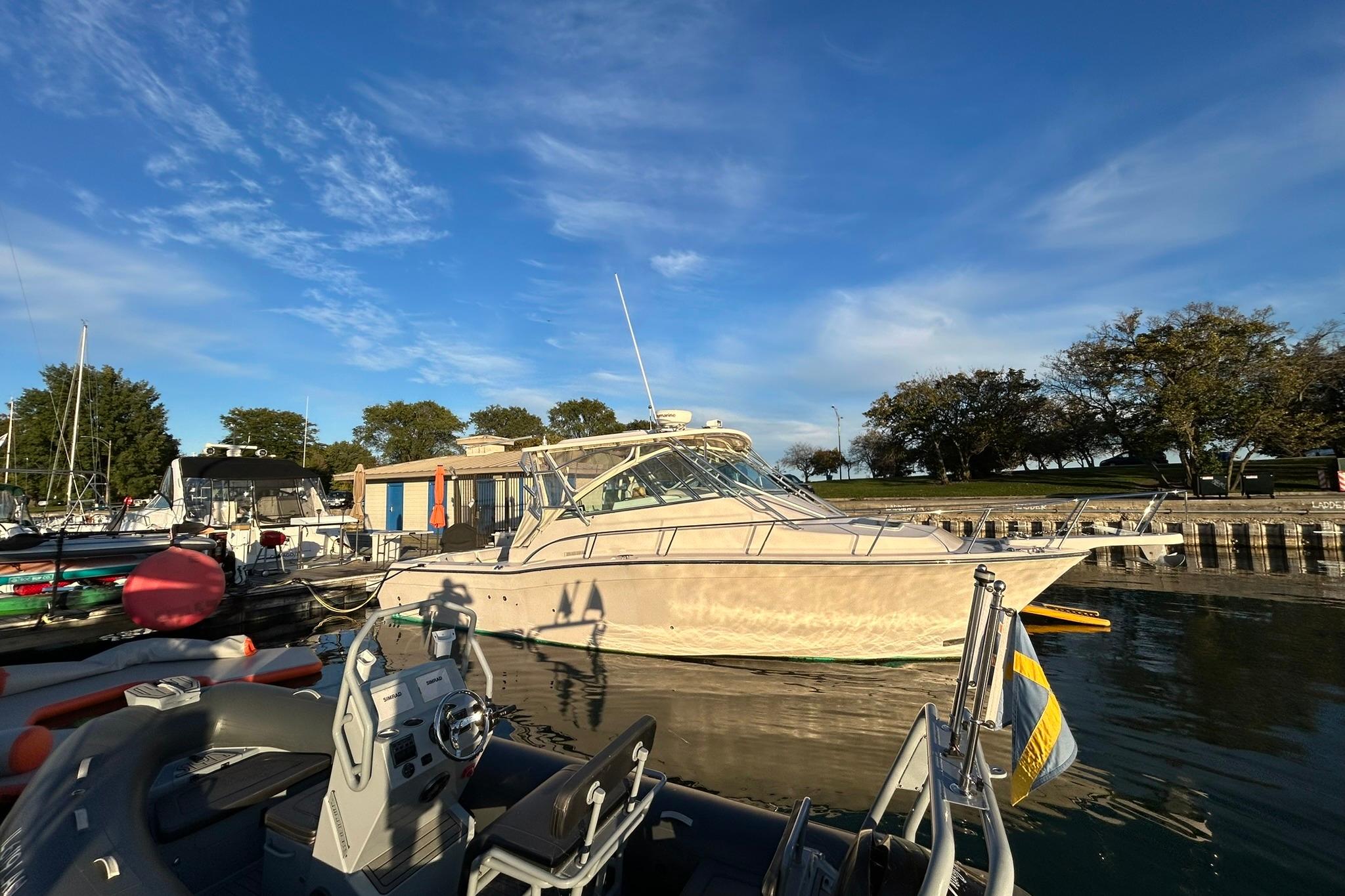 2007 Grady-White Express 360 boat docked at a marina under a clear blue sky.