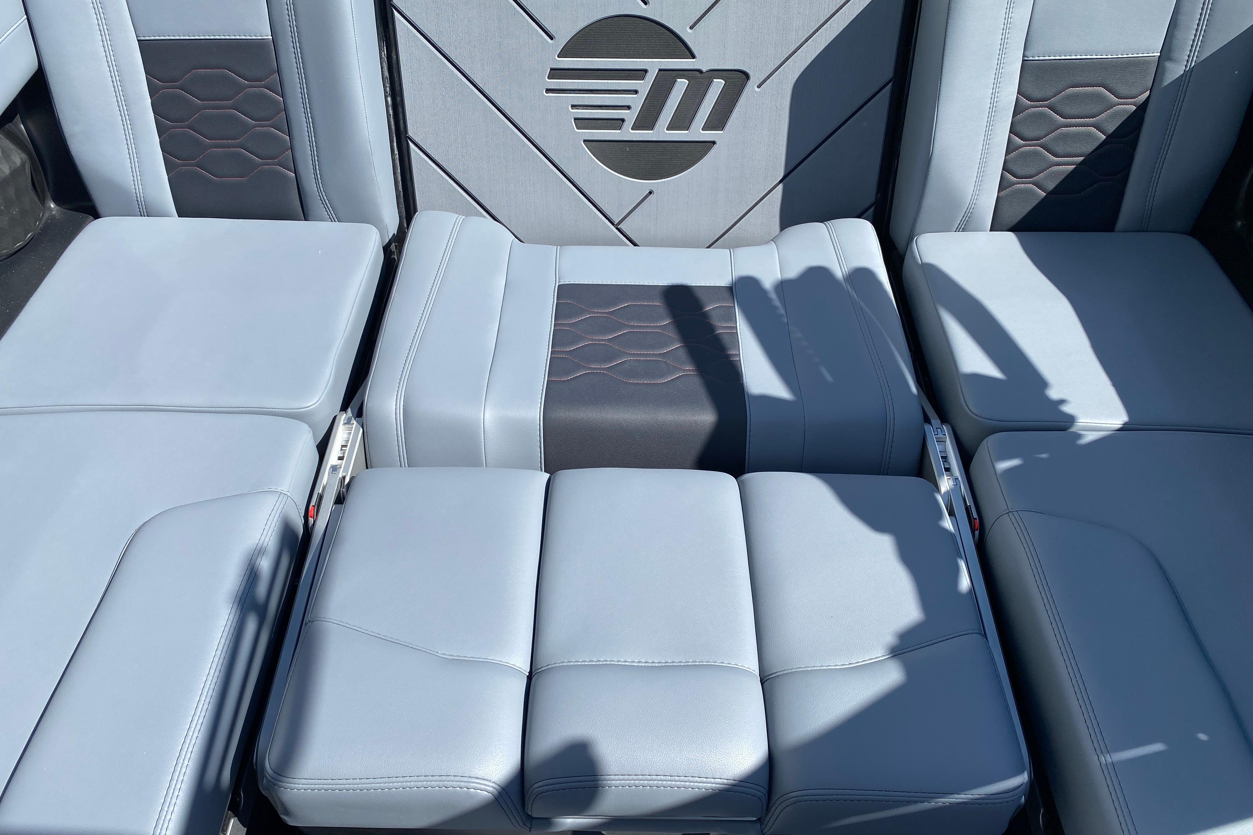 2025 Malibu Wakesetter 23 LSV interior seating with stylish upholstery and logo detail.