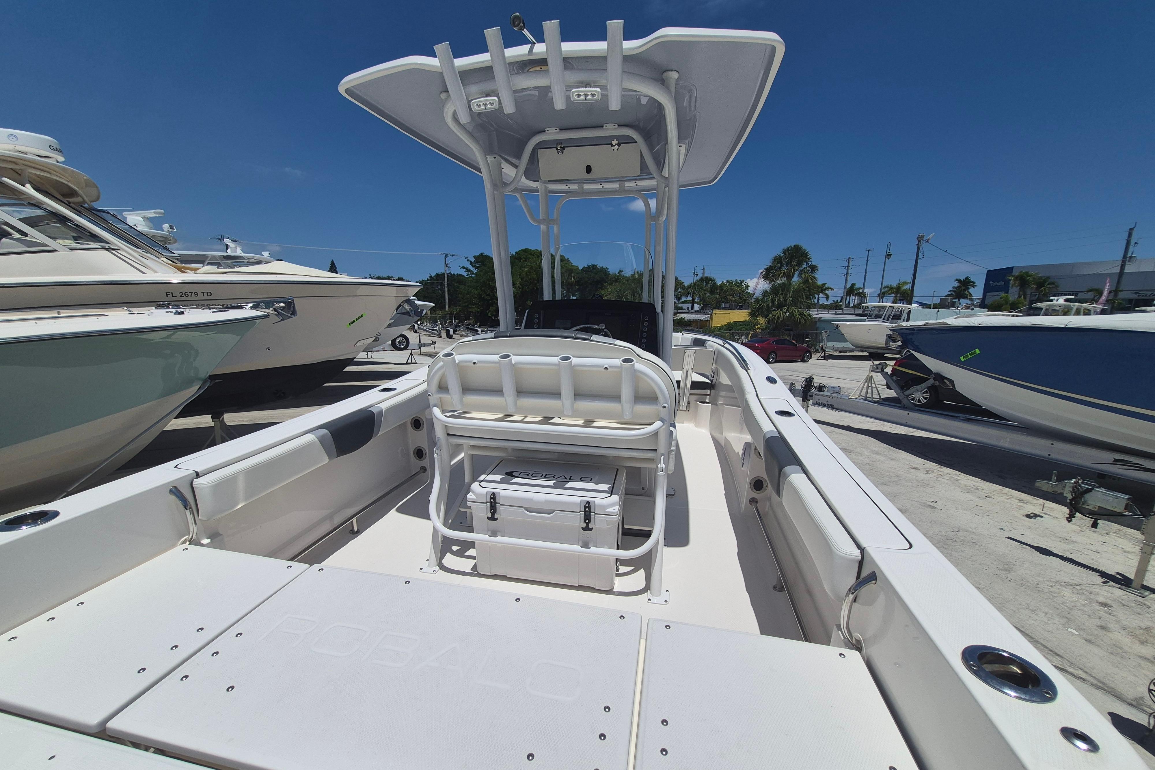 2023 Robalo R230 Center Console boat with spacious deck and seating, parked outdoors.
