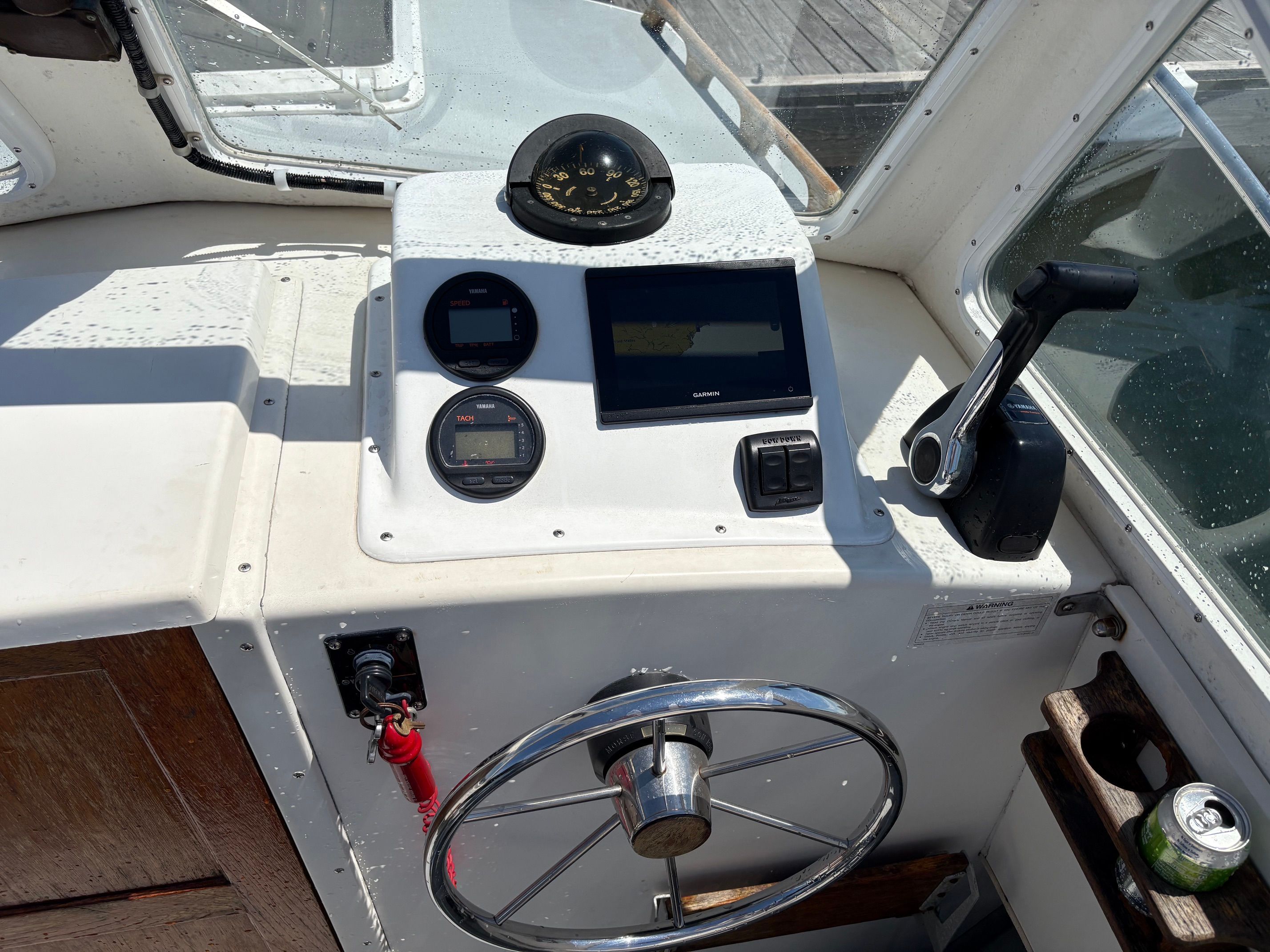 The cockpit of a 1990 Portsmouth 22 with a steering wheel, compass, and electronic displays.