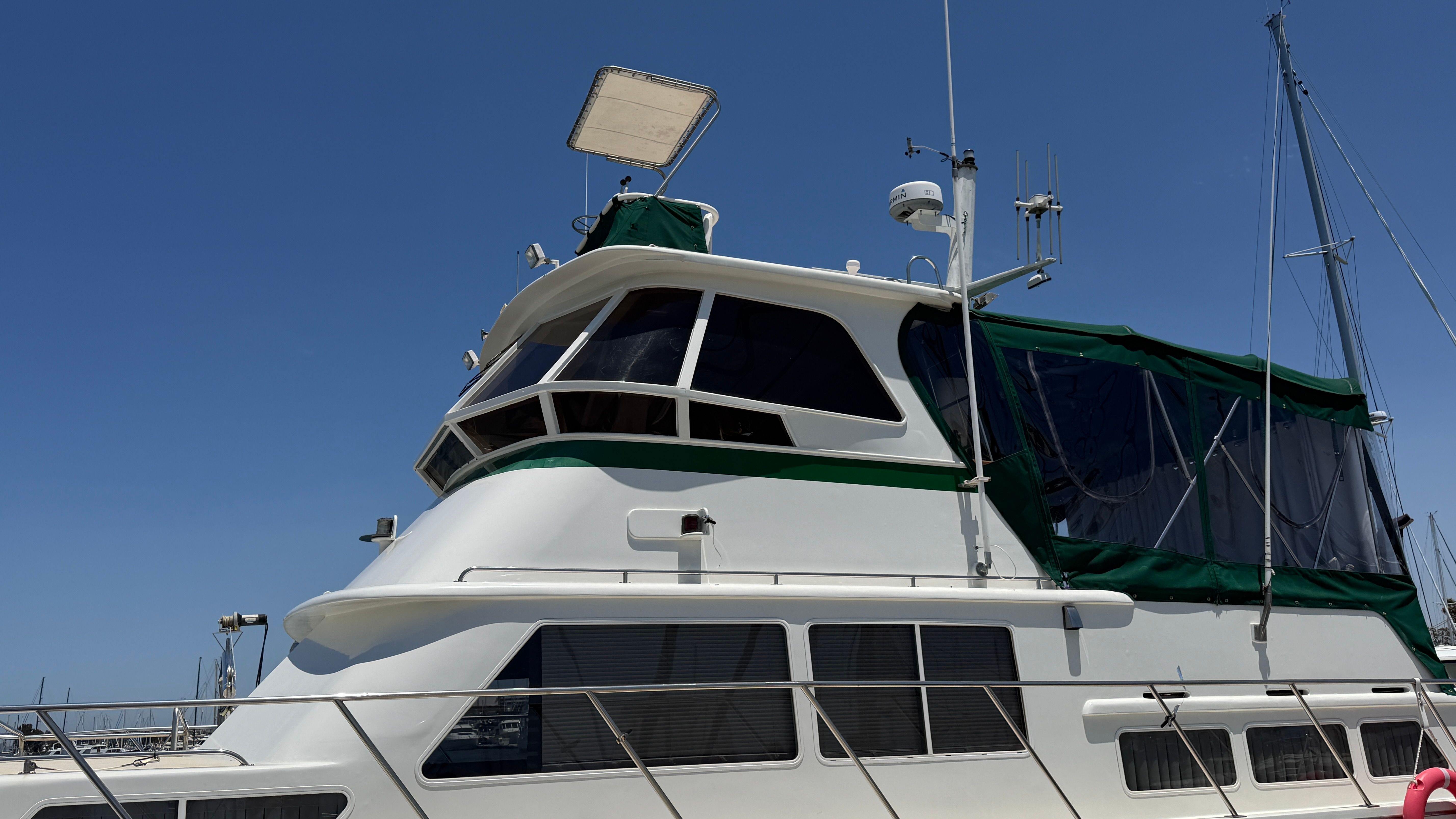 1966 Drake Yachtfisher with green canopy docked at harbor.