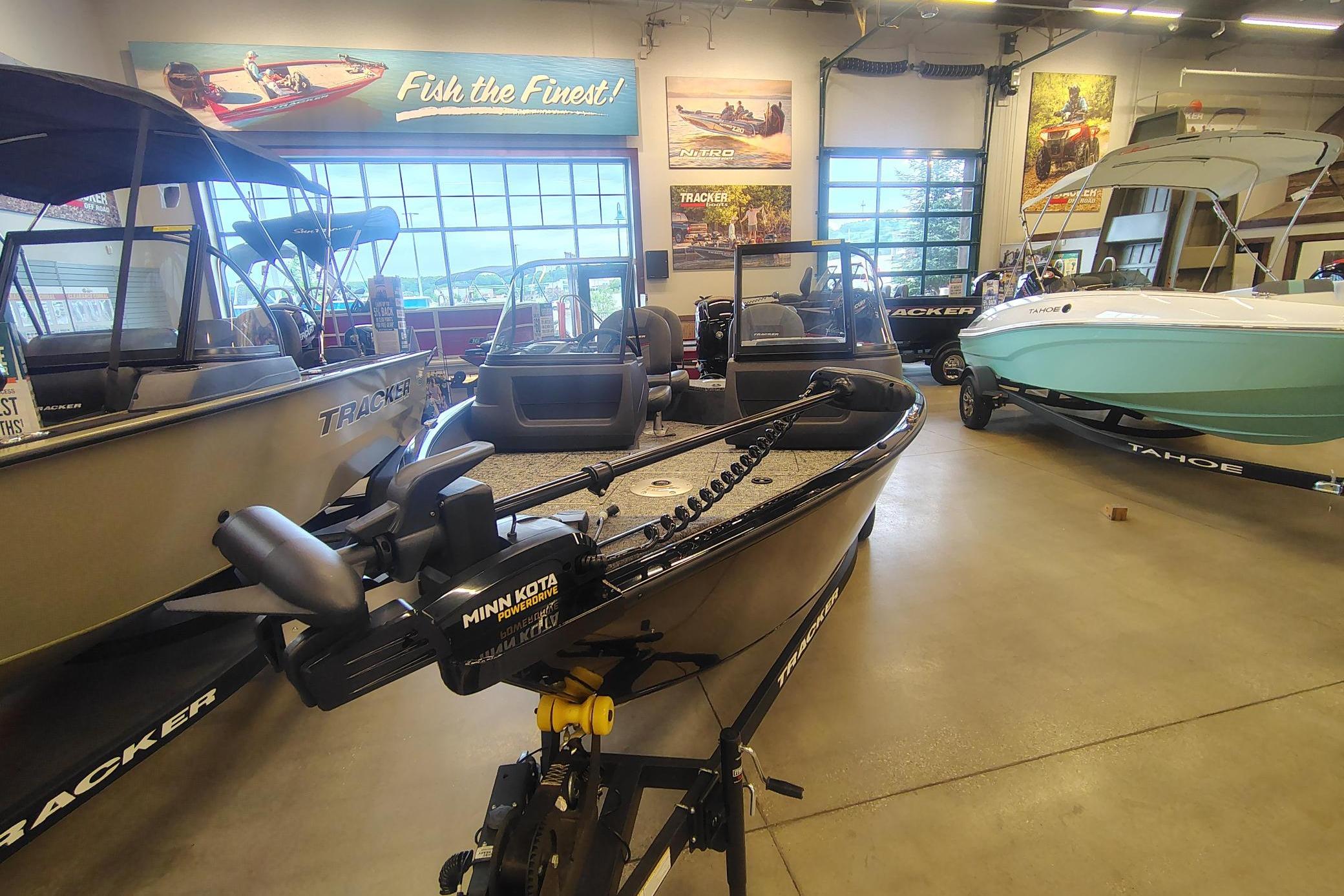 2026 Tracker Pro Guide V-16 WT boat displayed in showroom with Minn Kota motor.
