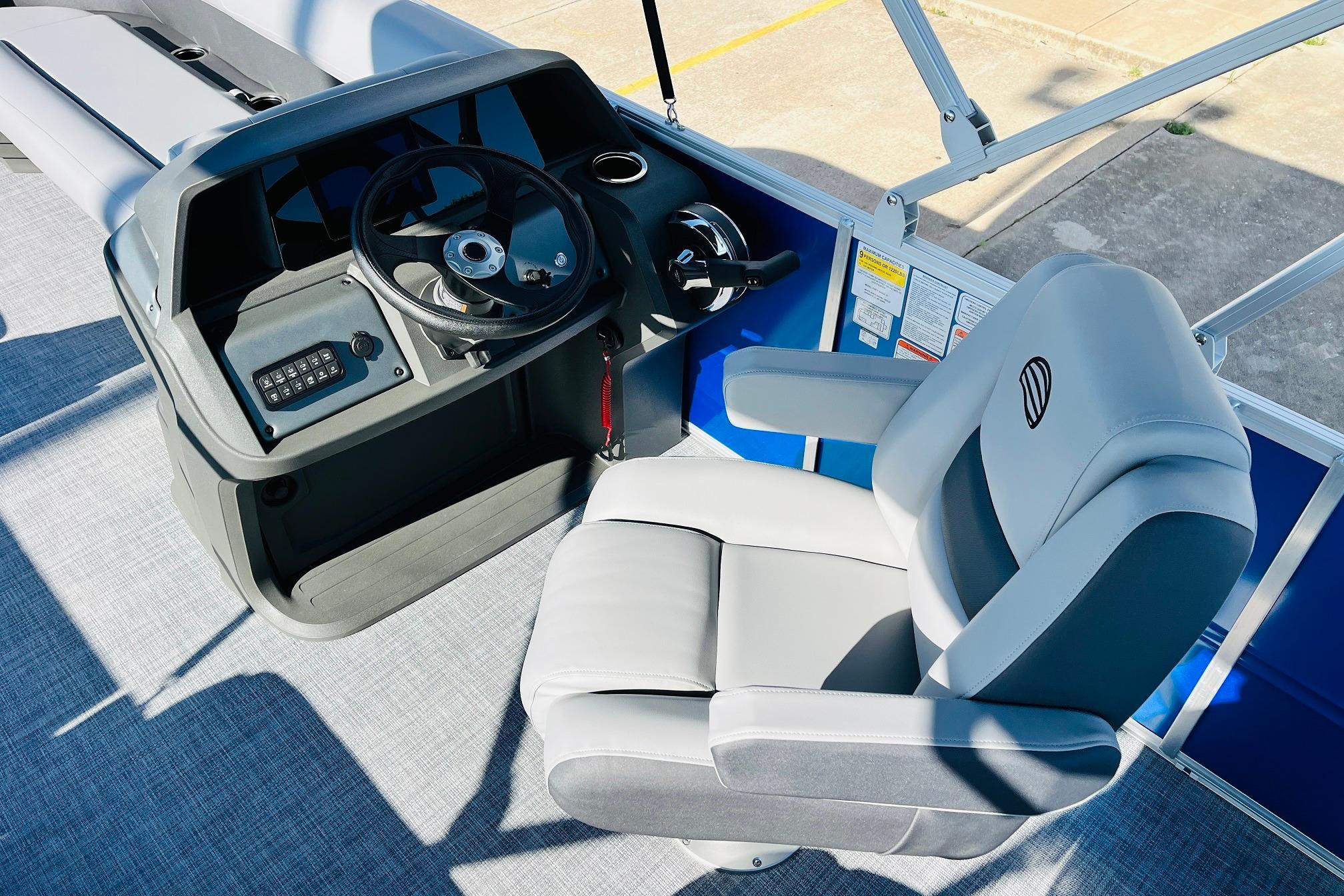 2026 Sun Tracker Party Barge 18 DLX helm with steering wheel and captain's chair.