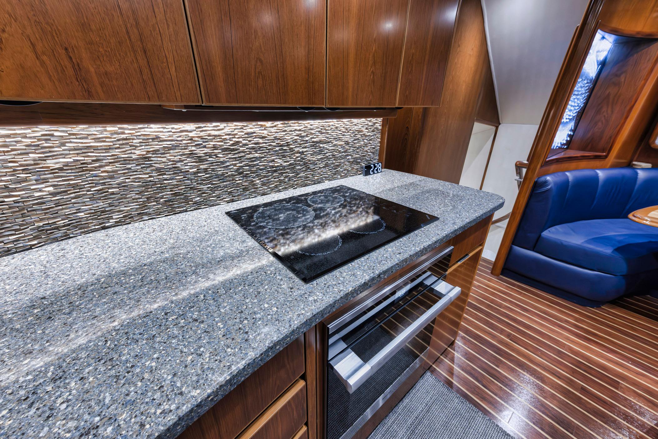 Modern kitchen in 2015 Viking 70 Convertible yacht with sleek countertops and wood cabinetry.