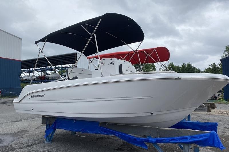 2025 Stingray 173CC boat with canopy on trailer, overcast sky background.