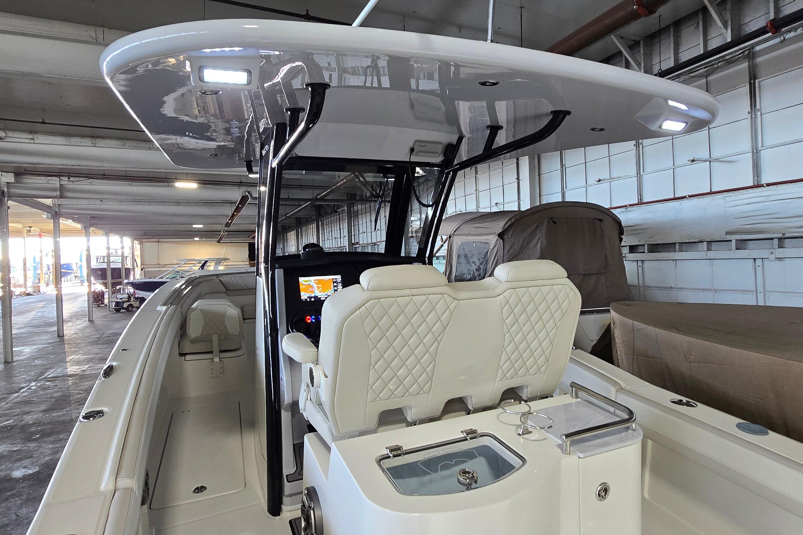 2024 WorldCat 280 CC-X boat interior with dual seats and modern dashboard in a warehouse.