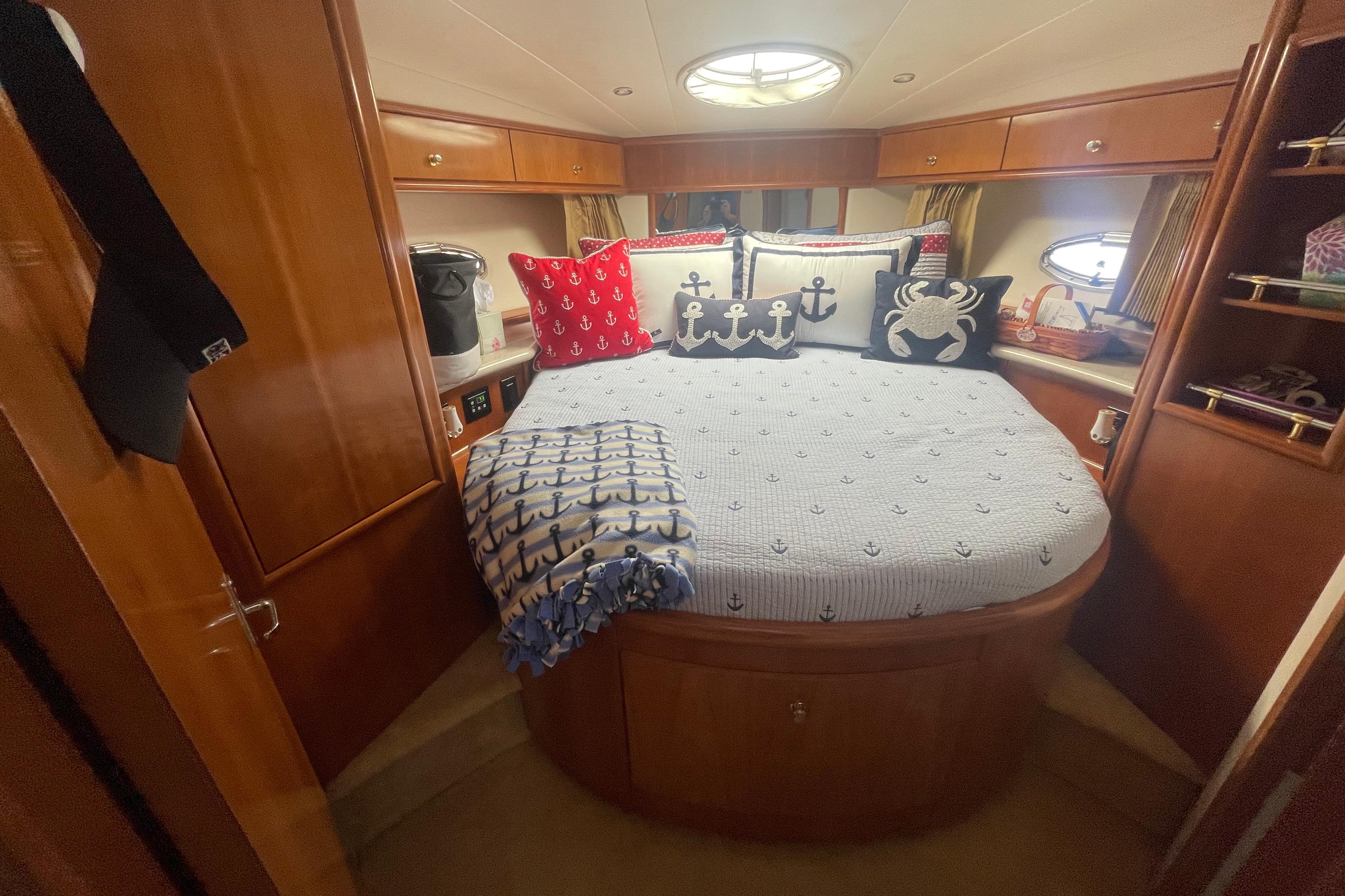 Luxurious 2002 Carver 410 Sport Sedan cabin with nautical-themed bedding and cozy decor.