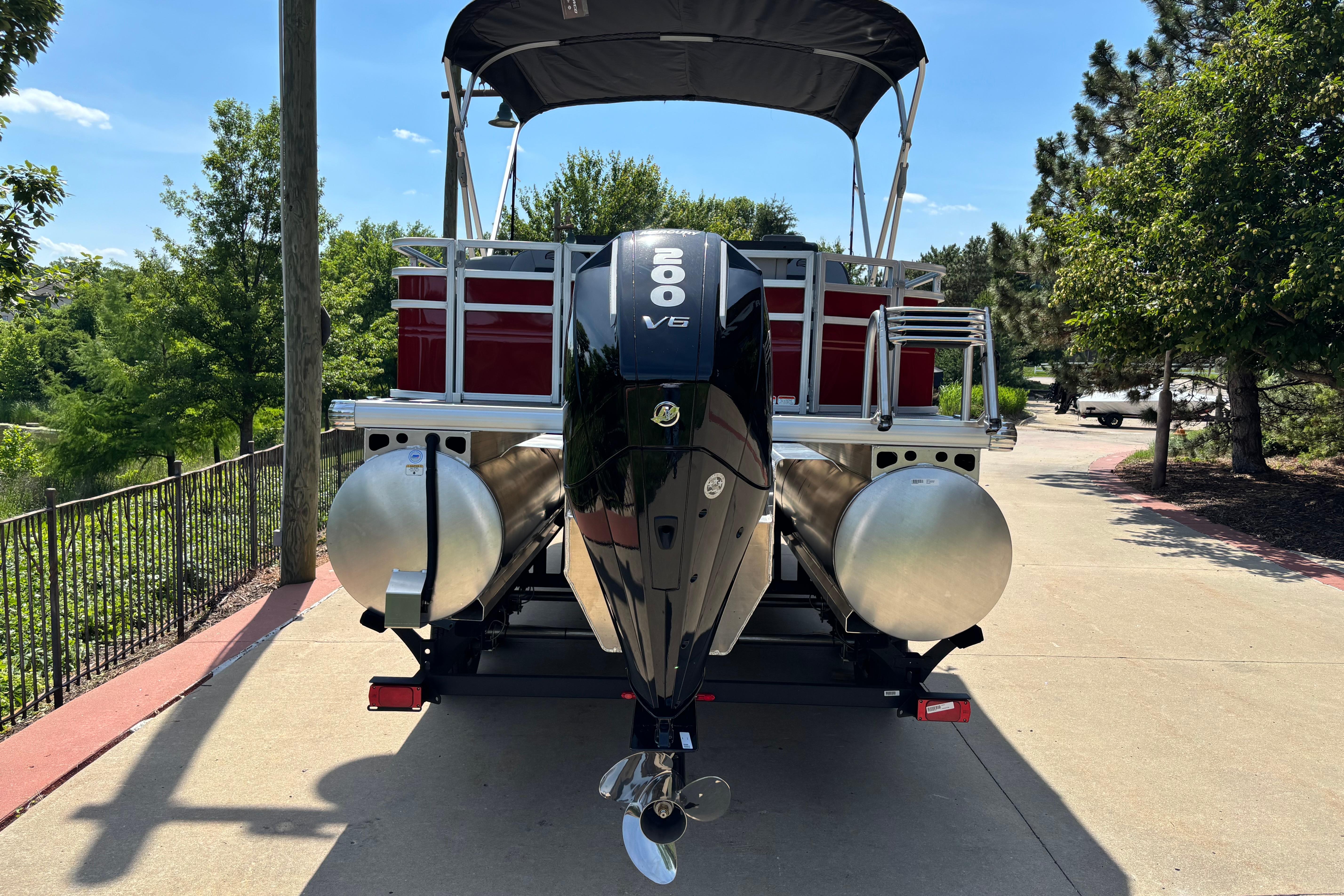 2026 Sun Tracker SportFish 22 XP3 pontoon boat with powerful engine, parked on a sunny day.