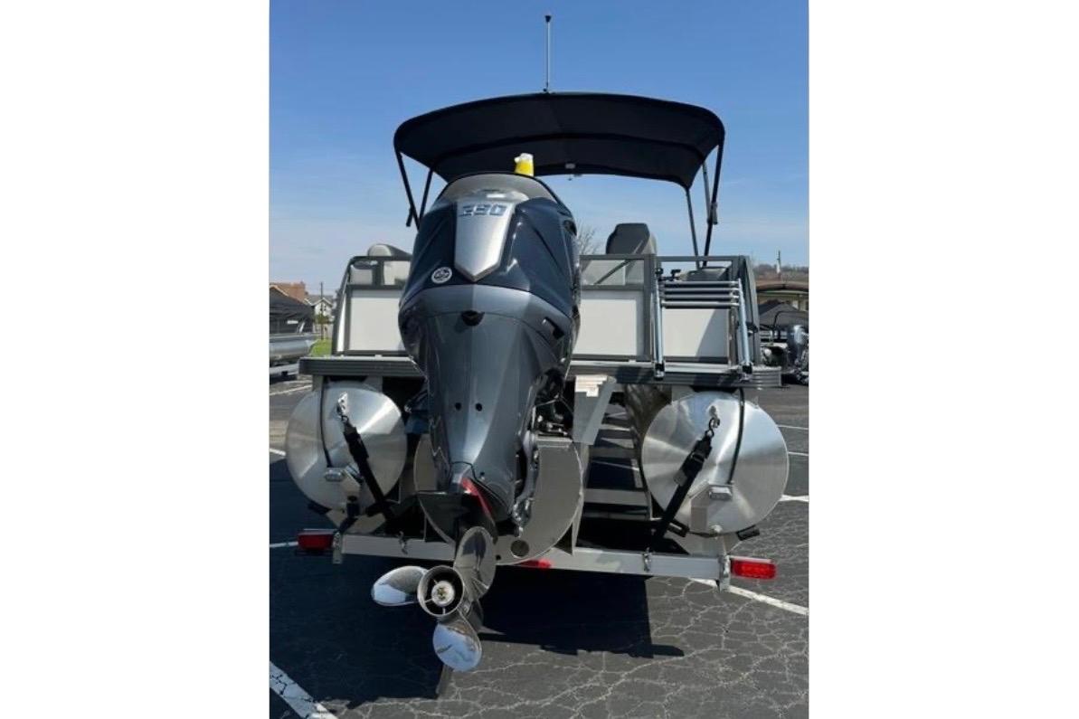 2025 Veranda Relax VR25VLC pontoon boat with powerful outboard motor, parked outdoors.
