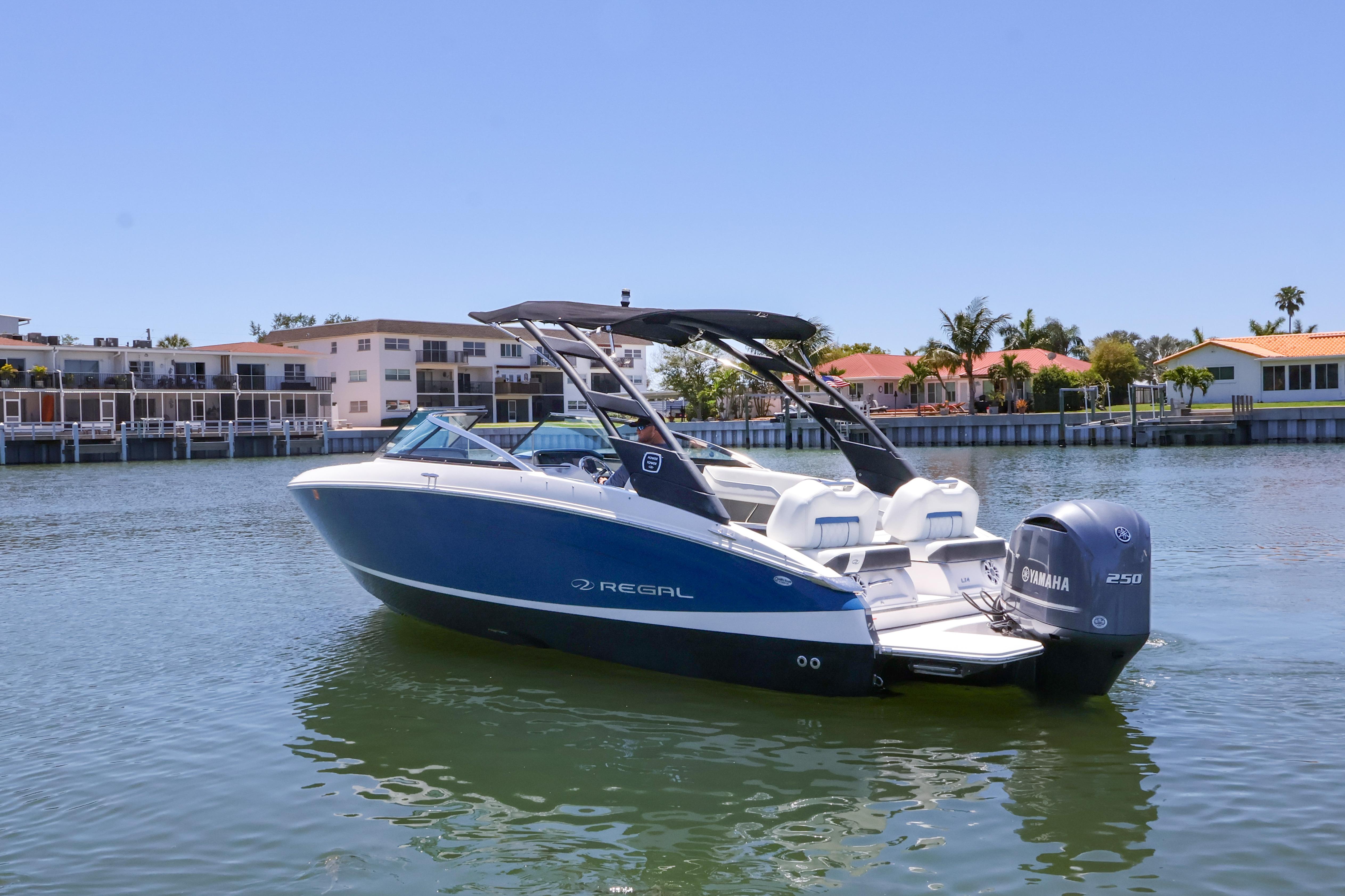 2020 Regal LX4 boat with Yamaha engine on calm water near waterfront homes.