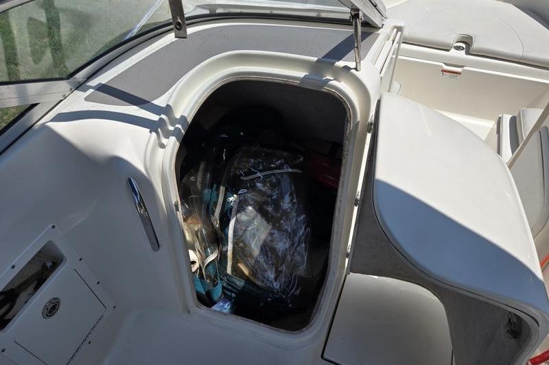 Storage compartment of a 2004 Aquasport 215 Osprey Sport boat, partially open.