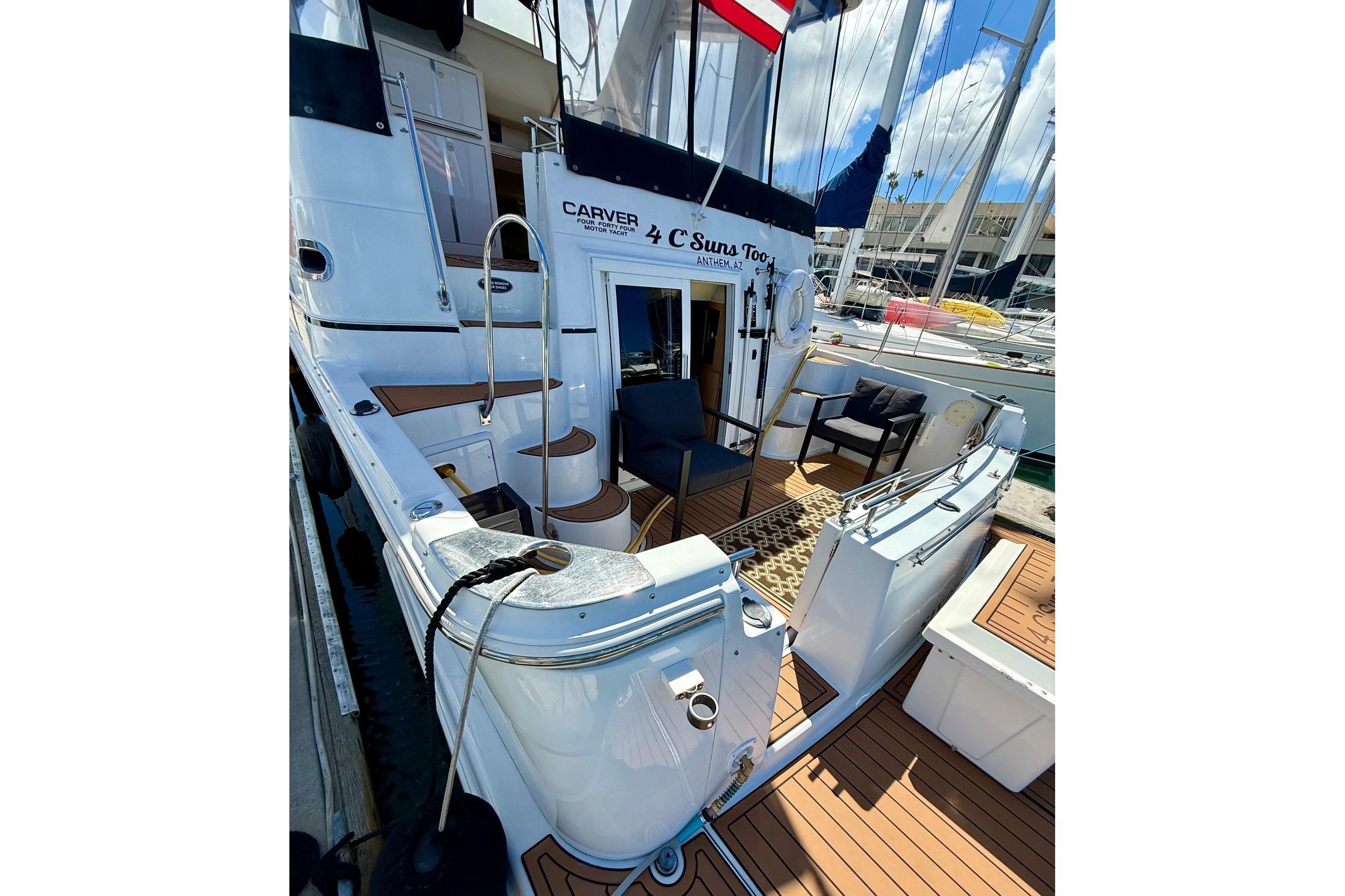 2001 Carver 444 Cockpit Motor Yacht docked, featuring spacious aft cockpit seating area just outside the master cabin perfect for morning coffee.