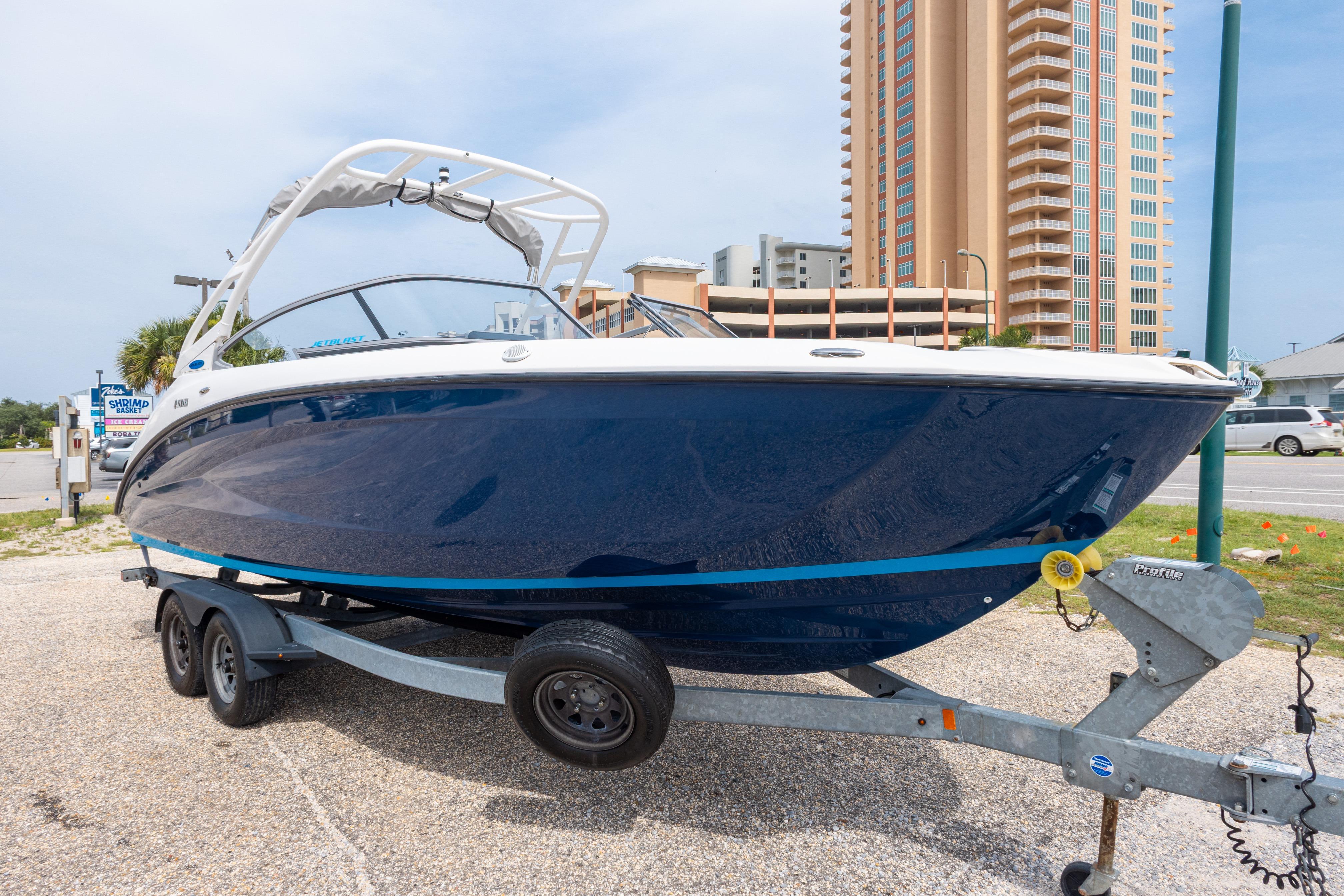 2021 Yamaha Boats AR250 on trailer, parked near tall building, ready for adventure.