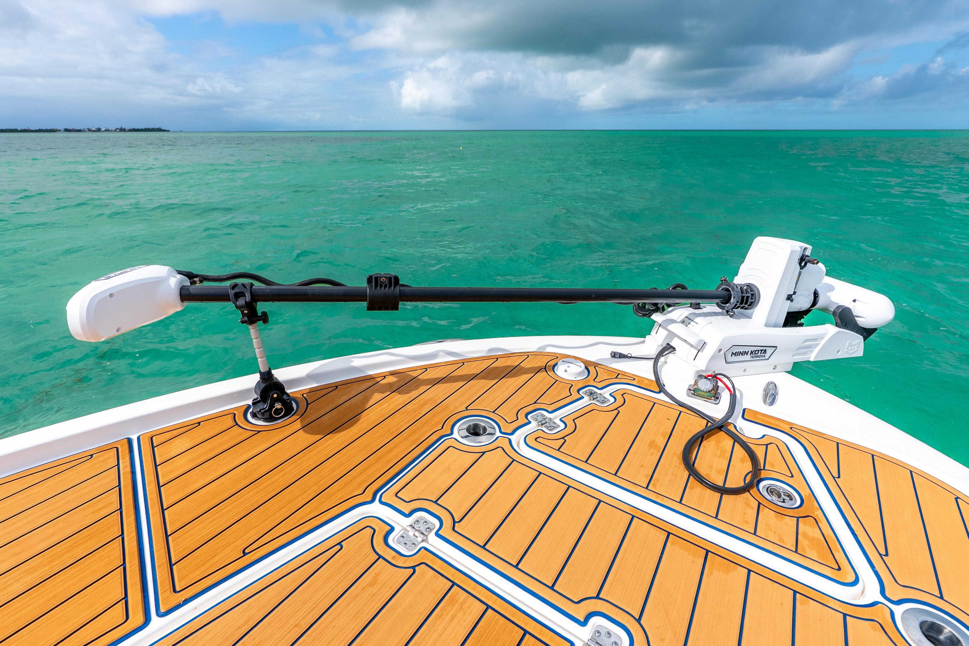 2024 Caymas 281 HB boat deck with Minn Kota trolling motor on turquoise water.
