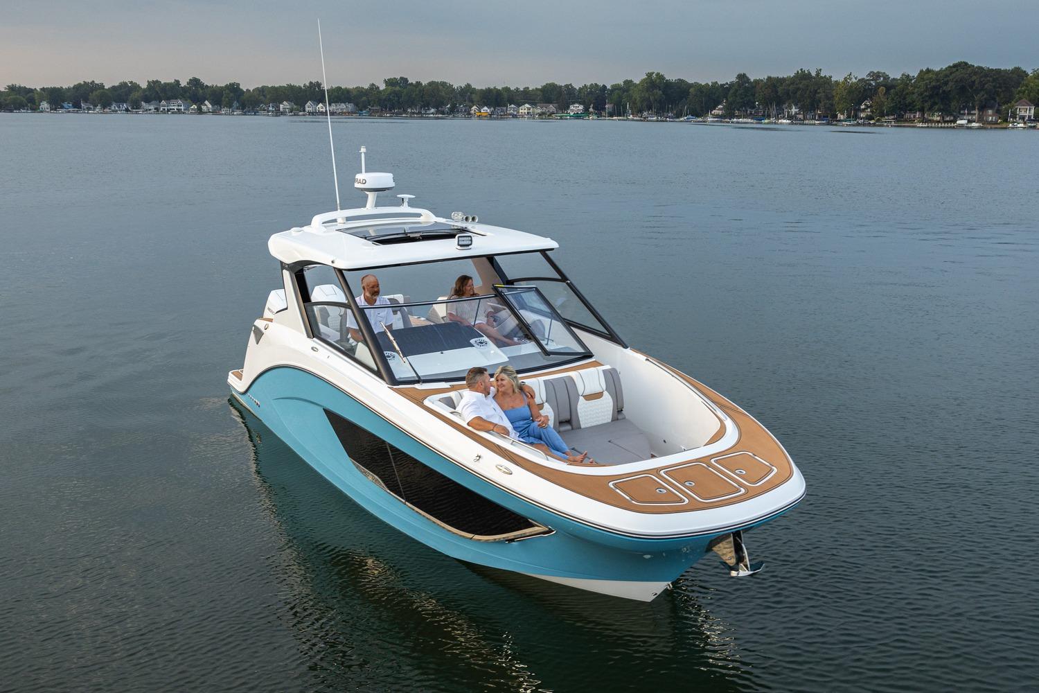 2026 Hurricane SunDeck 3200 OB cruising on a serene lake with passengers enjoying the ride.