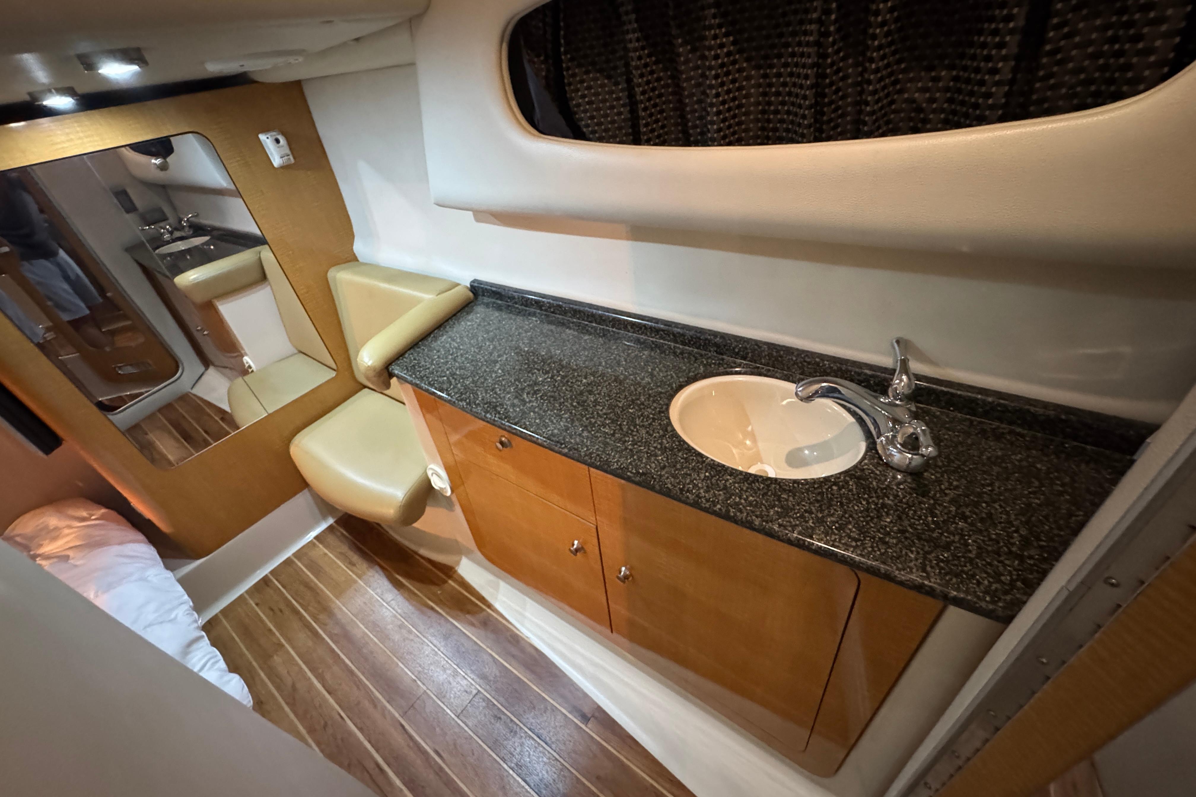 Luxurious bathroom interior of 2006 Chaparral 330 Signature yacht with wood accents and modern fixtures.