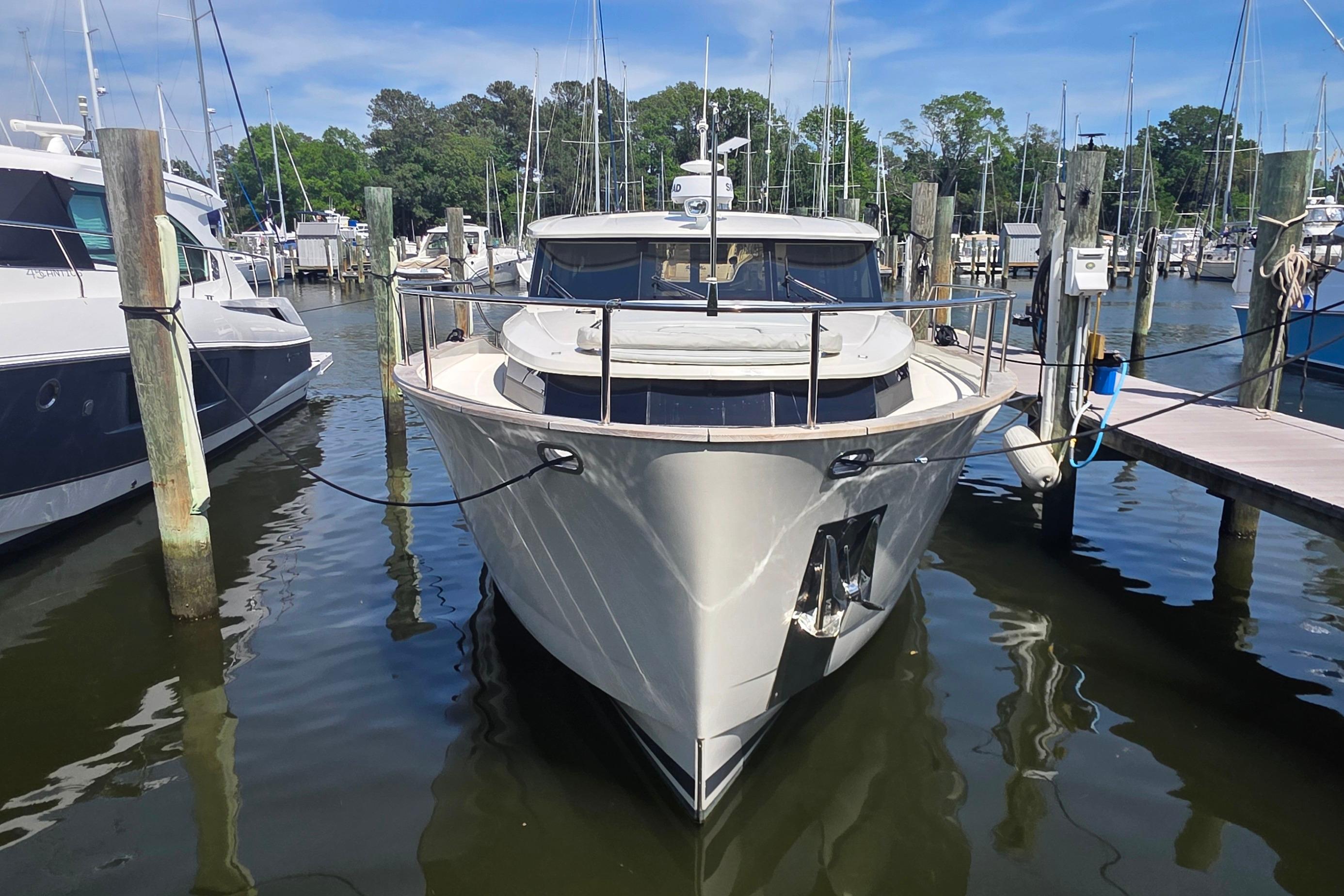 2023 Greenline 40 yacht docked at a marina, surrounded by other boats.