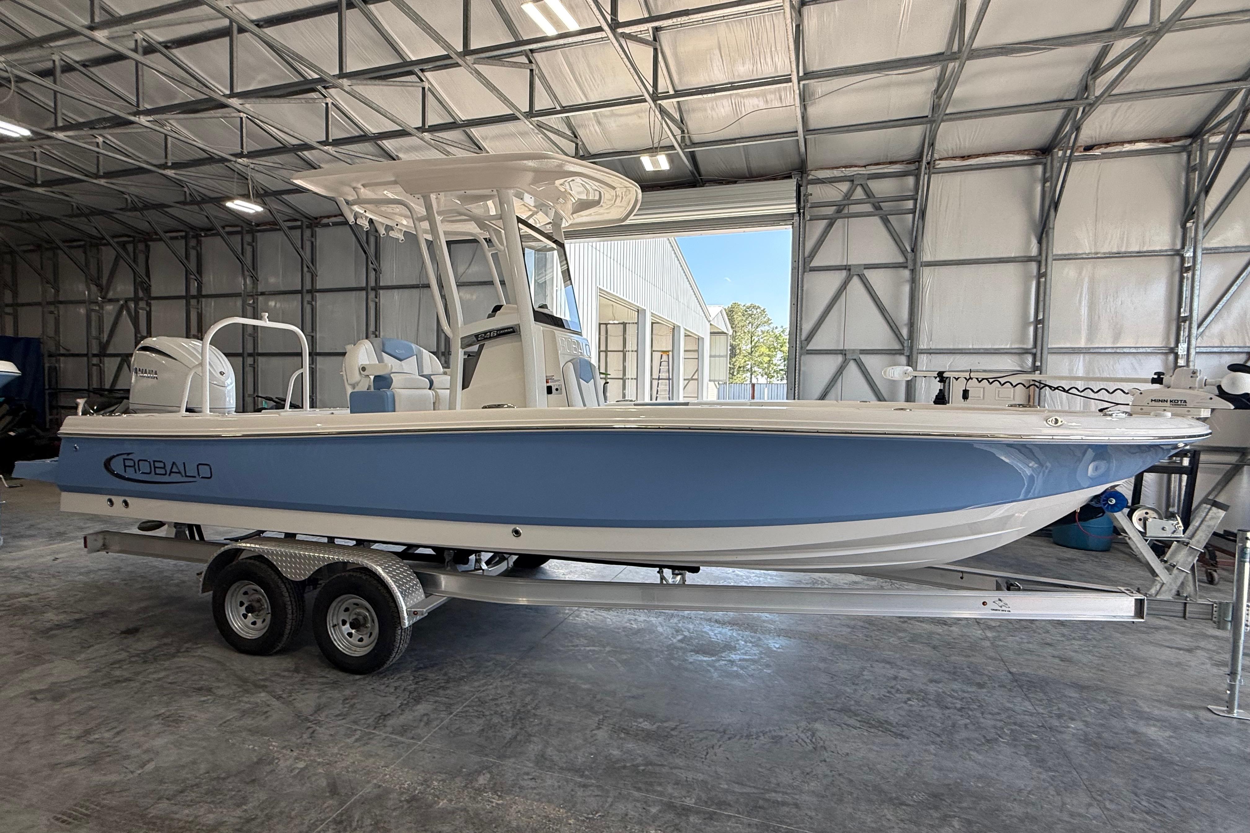 2026 Robalo 246 Cayman boat in a warehouse on a trailer.