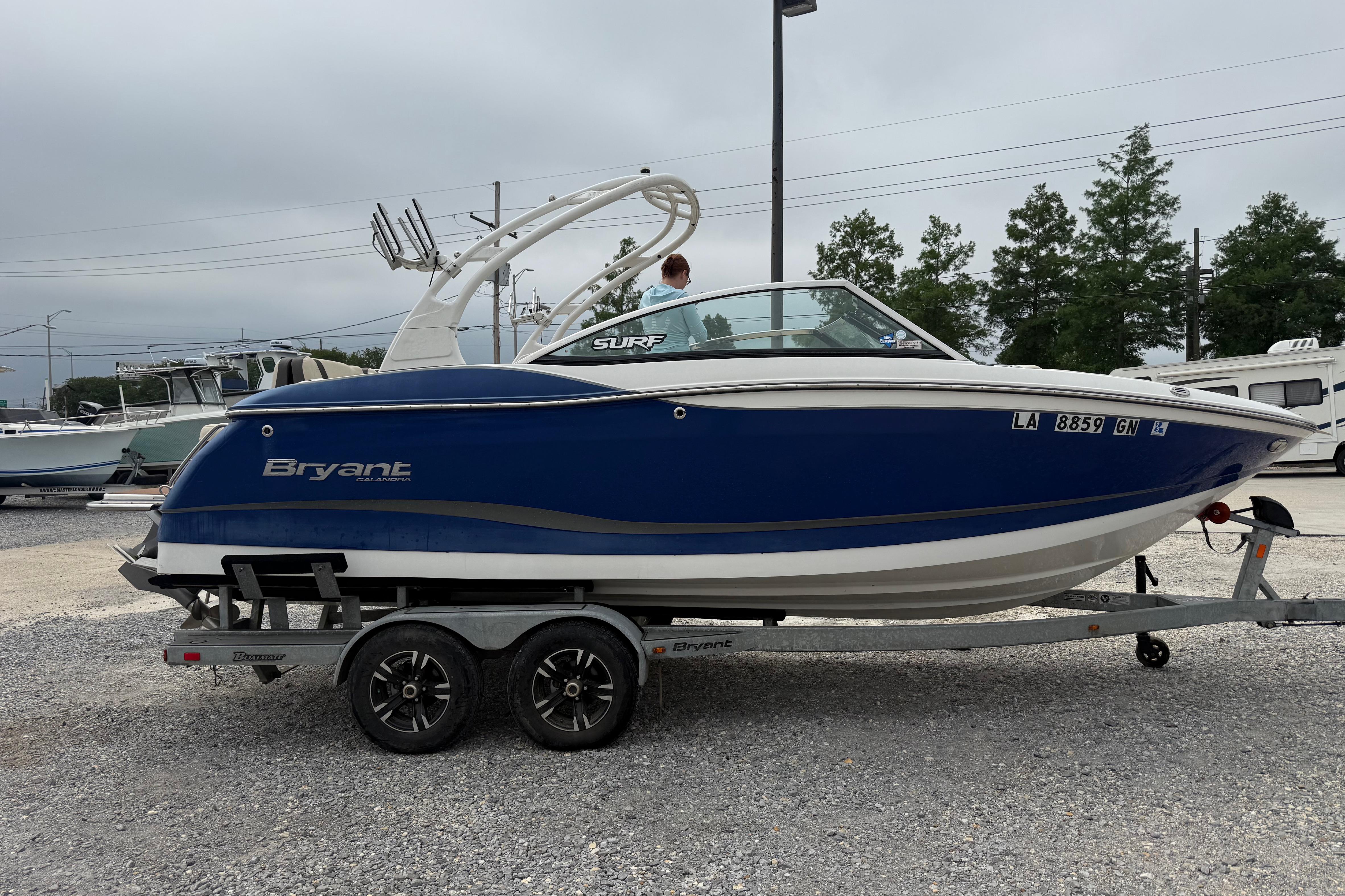 2018 Bryant Calandra boat on trailer, blue and white design, parked outdoors.