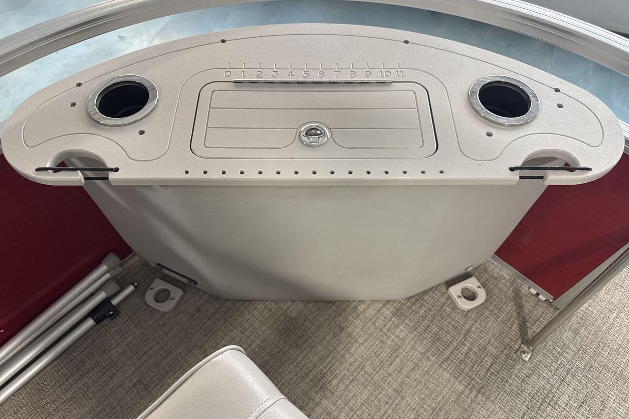 Control panel of 2022 Landau ALURE 232 boat with cup holders and storage compartment.