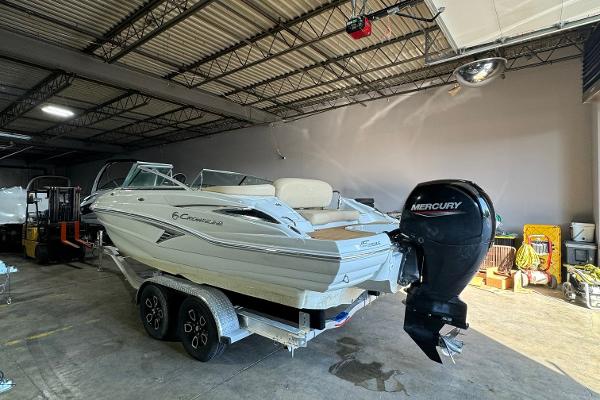 2023 Crownline 215 XS boat with Mercury engine in a warehouse.