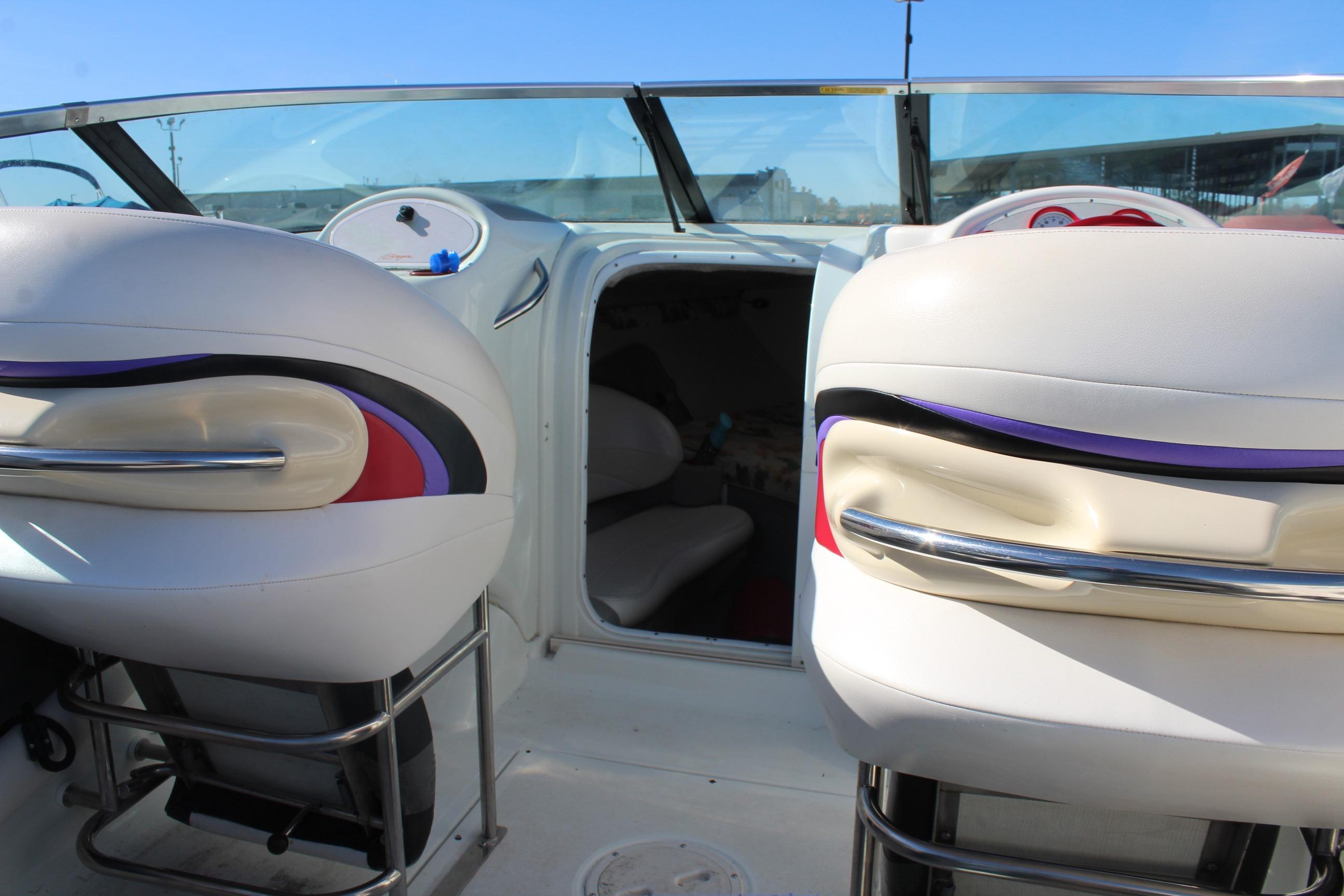 Interior of a 1996 Baja 232 boat with white and purple seating.