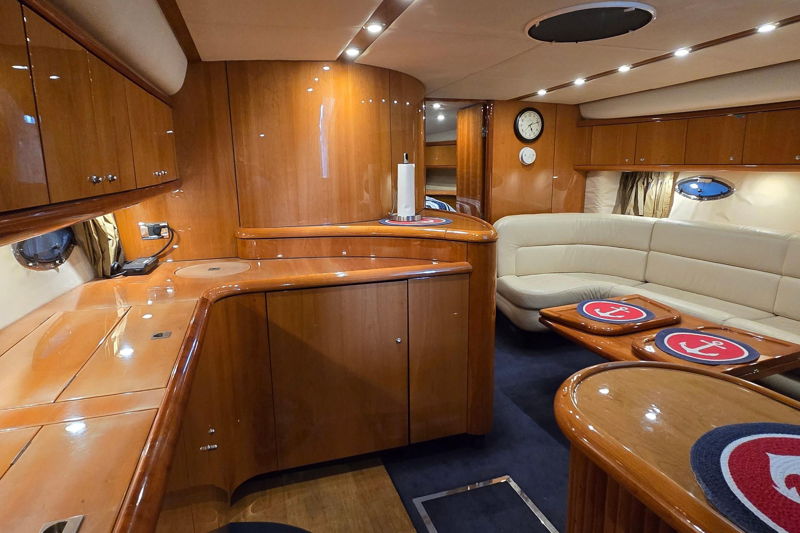 Luxurious interior of 2004 Sunseeker Camargue 50 yacht with elegant wood finish and seating area.