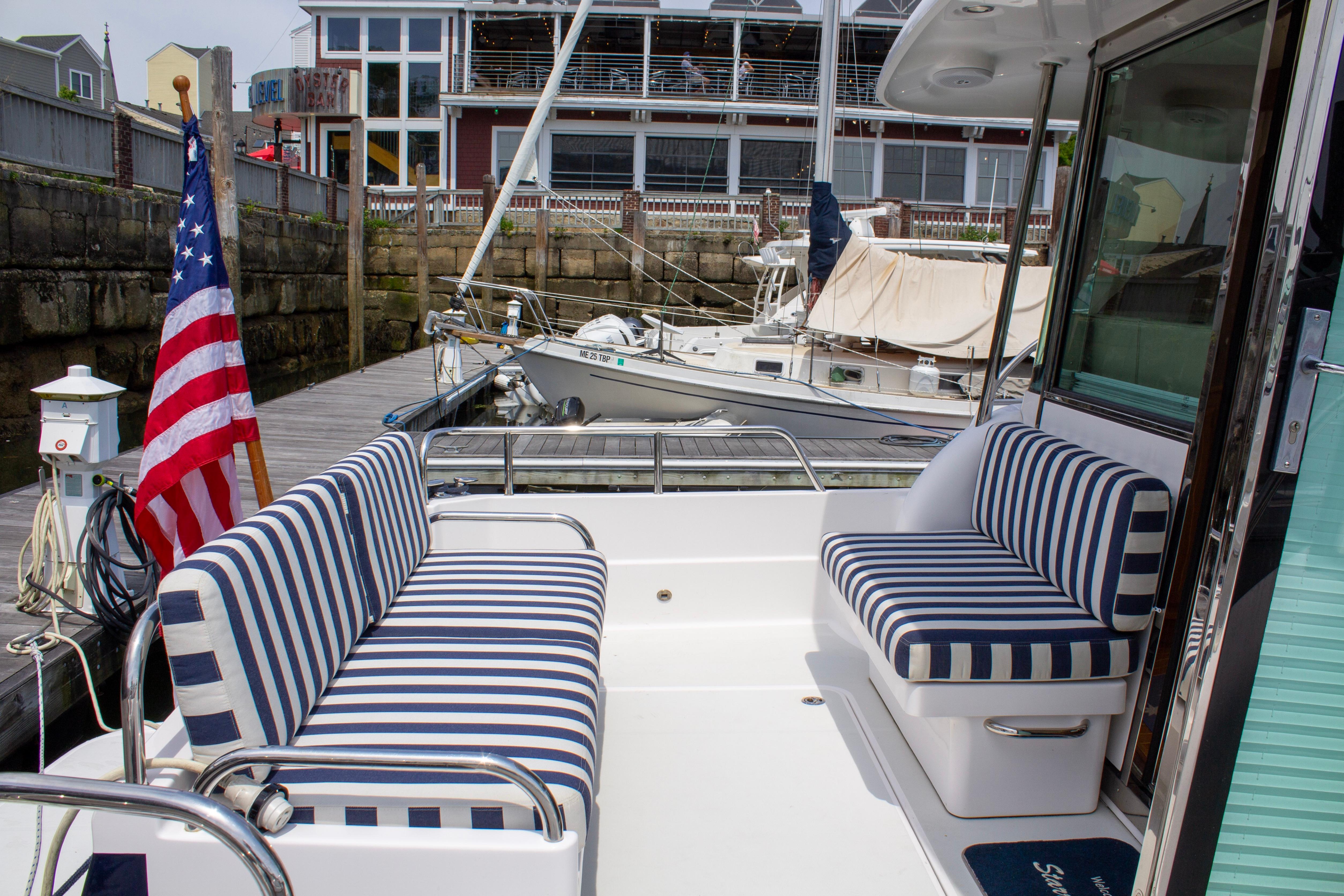 2013 Sabre 38 Salon Express yacht with striped seating and American flag at dock.
