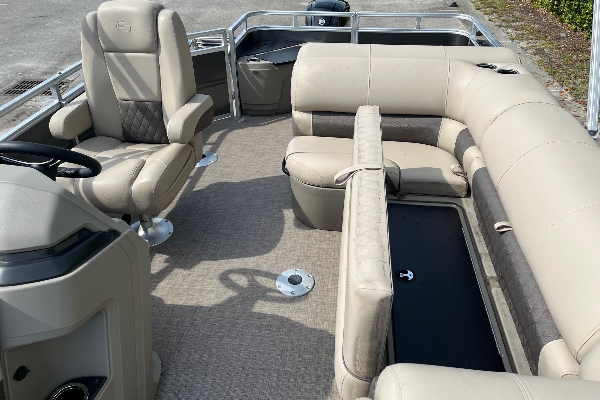 2025 Sun Tracker Fishin' Barge 20 DLX interior with beige seating and steering console.