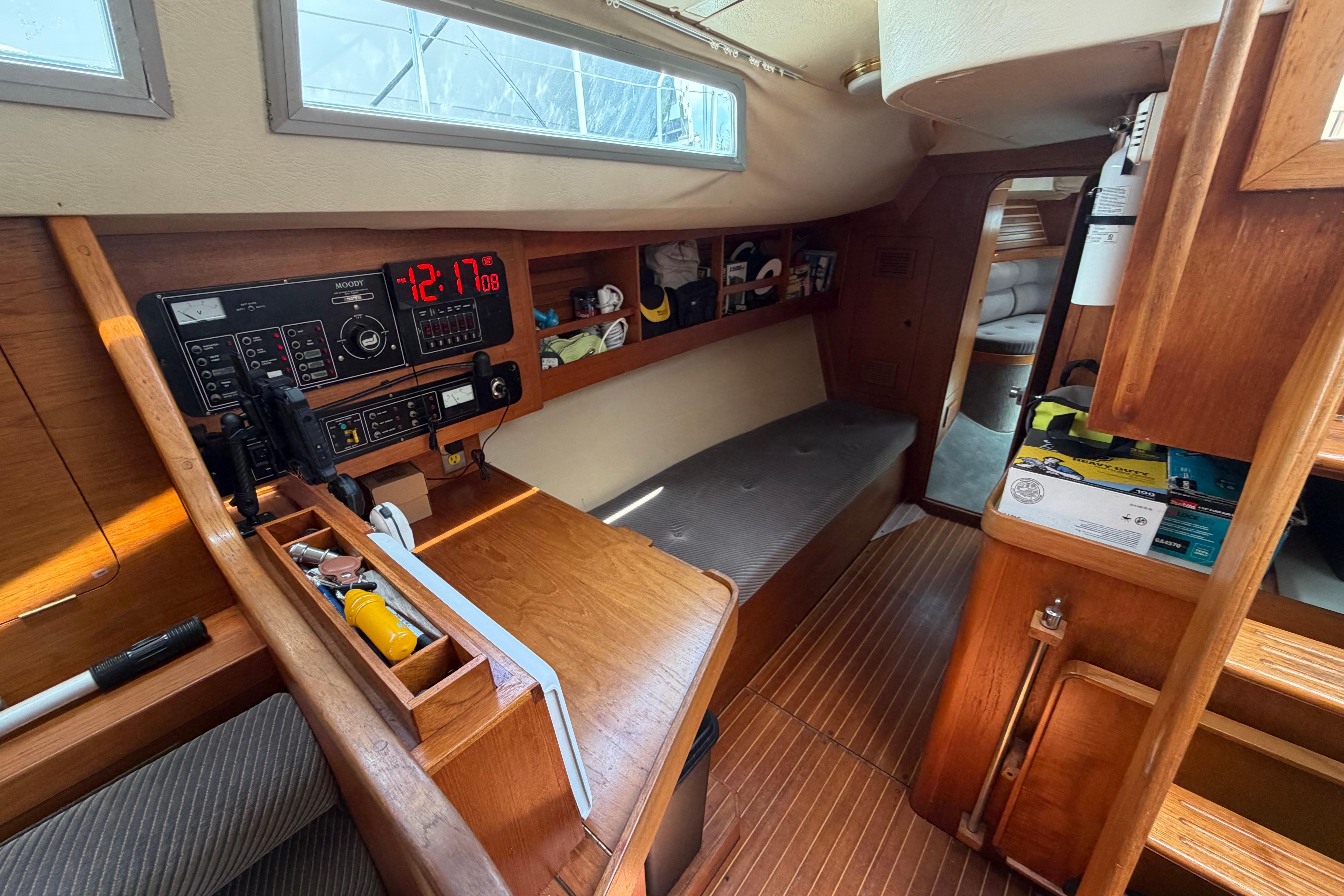 Interior of a 1987 Moody 376 sailboat with navigation equipment and wooden furnishings.
