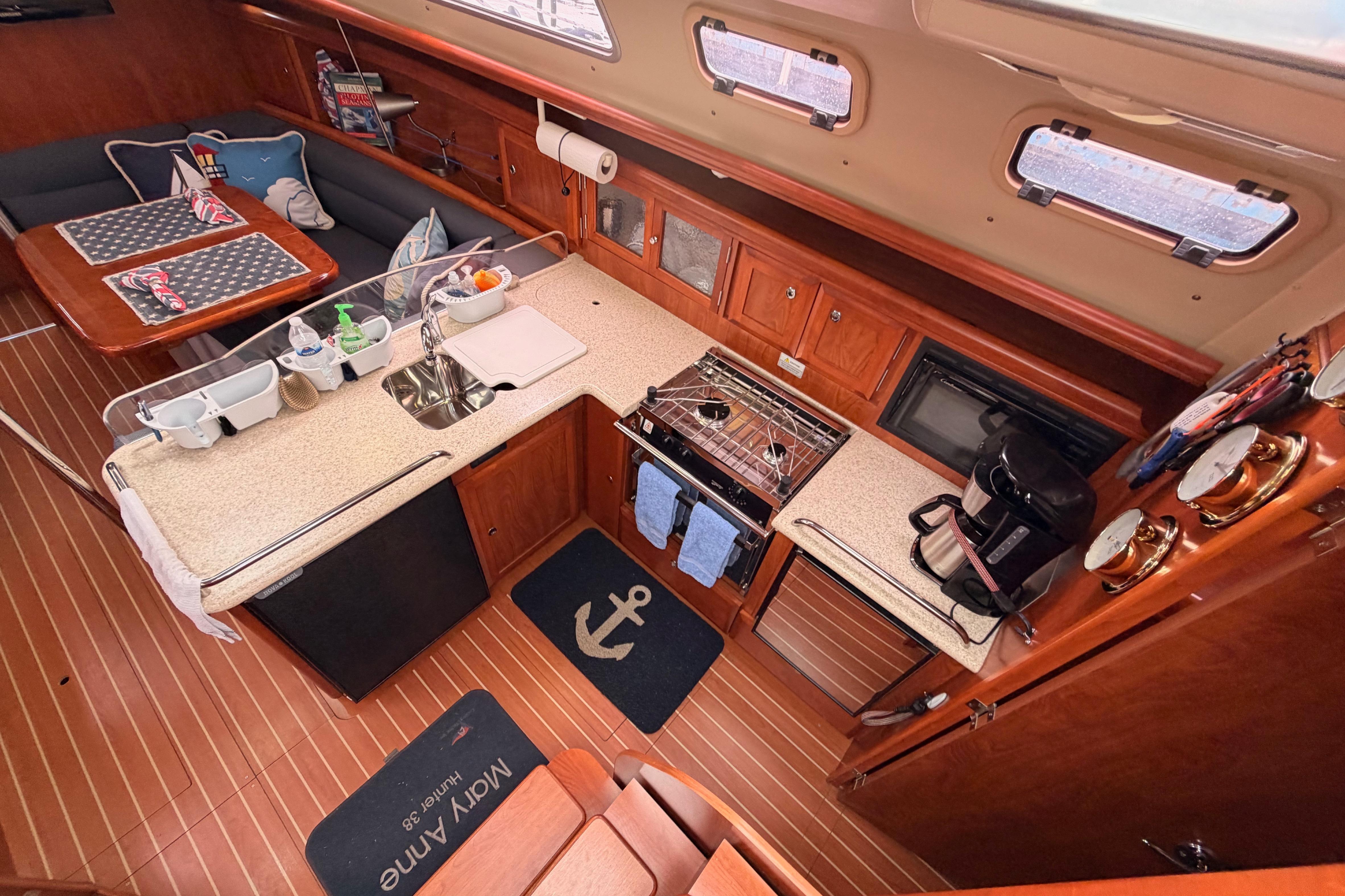 Interior of 2009 Hunter 38 sailboat galley with wood finish and modern amenities.