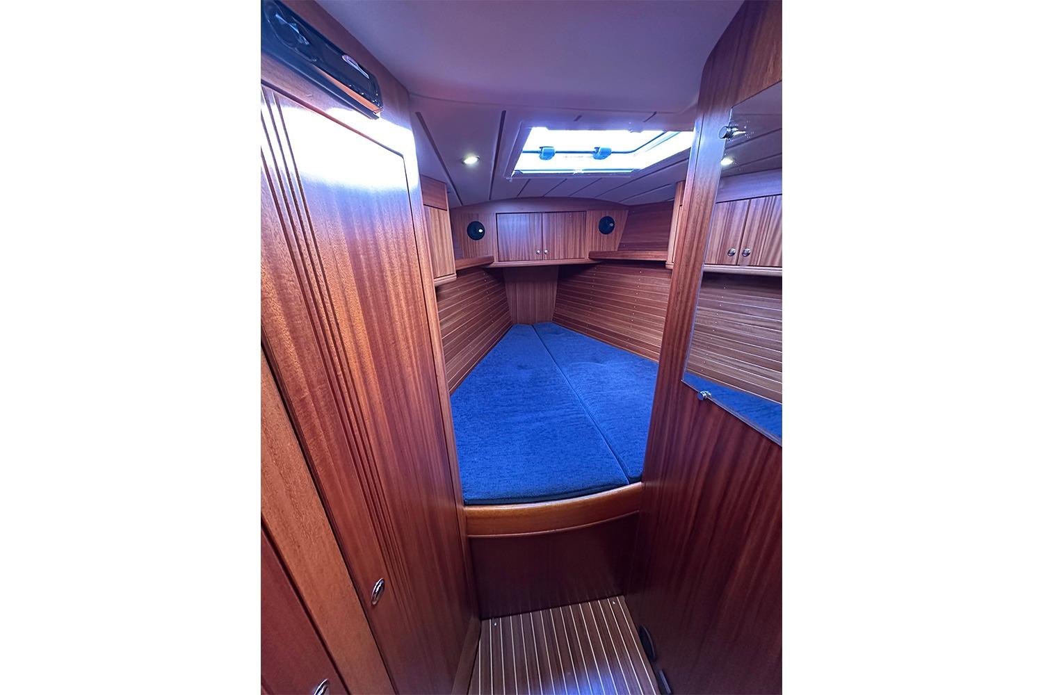 Interior cabin of 2004 Najad 460 yacht with wooden finish and blue bedding.
