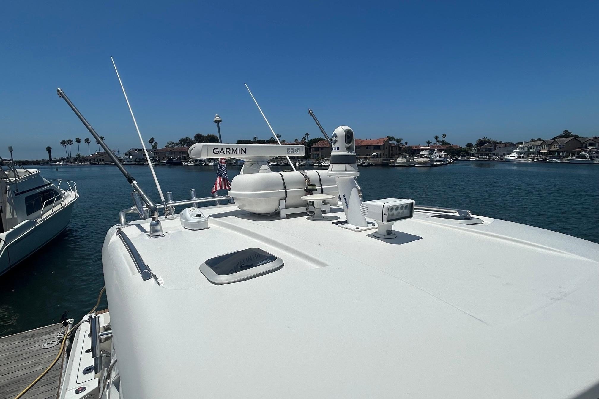2019 Pursuit OS 355 Offshore boat docked, featuring Garmin radar and FLIR camera, under clear blue sky.