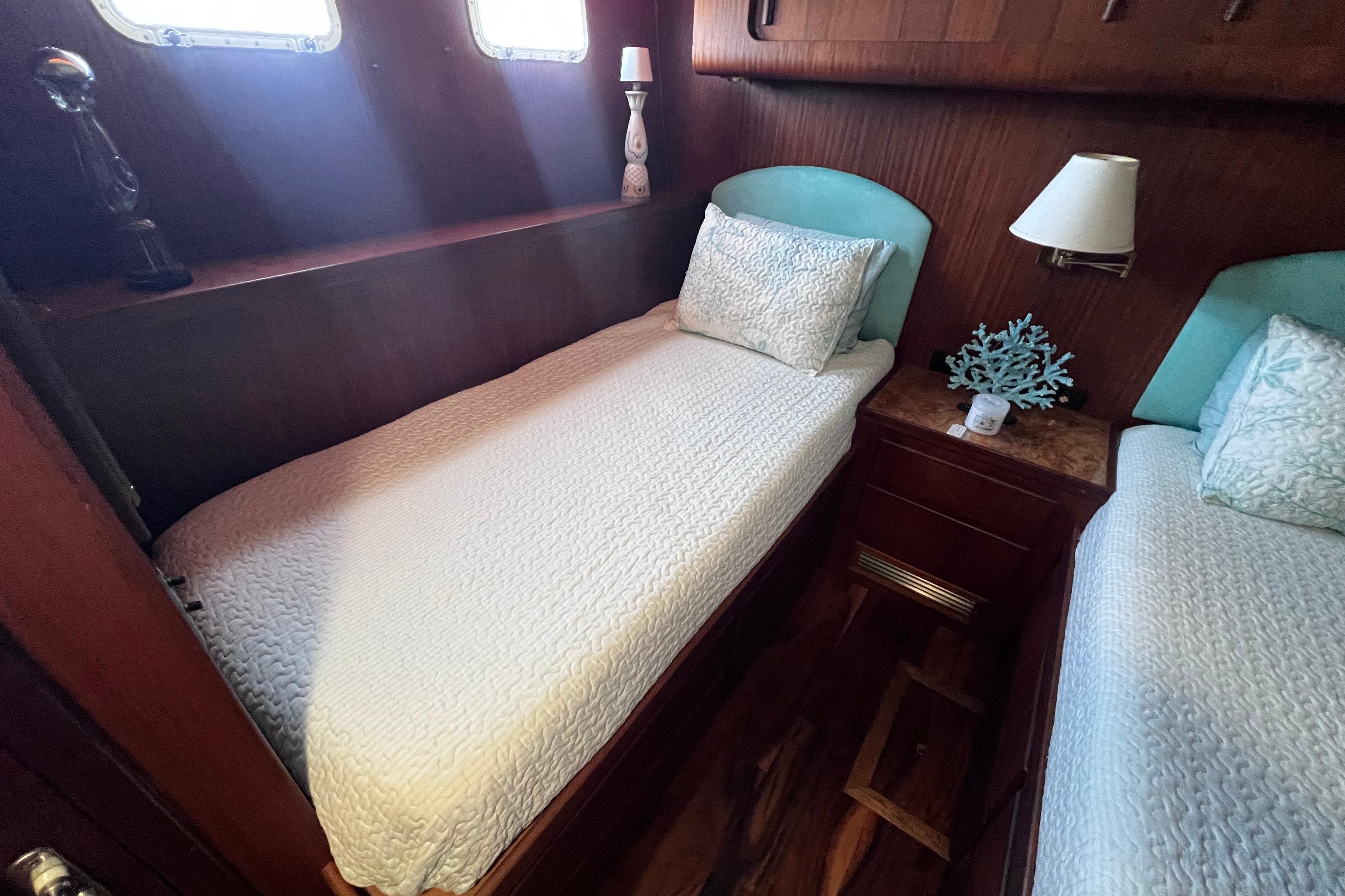 Twin beds in a cozy cabin of a 1987 Hatteras 70 Cockpit Motor Yacht.