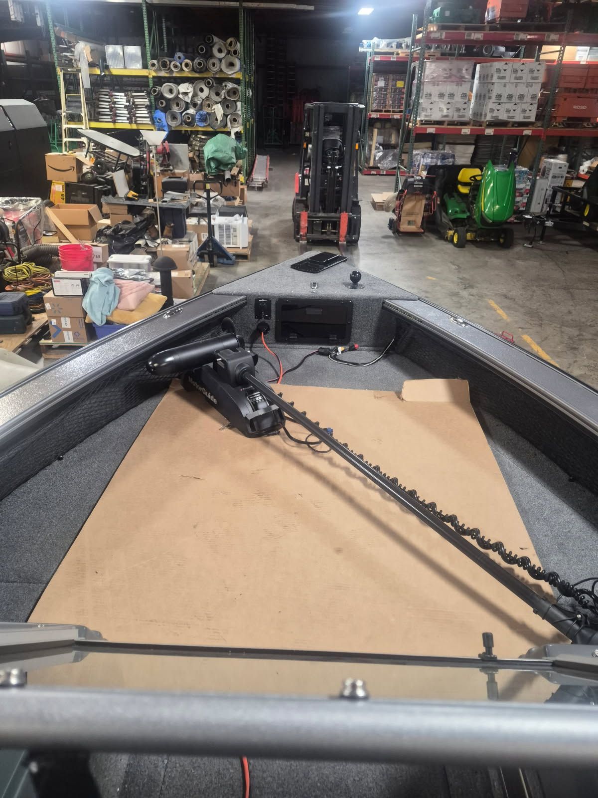 The image shows the bow deck of a Lund Pro-V 2075 boat in a warehouse.