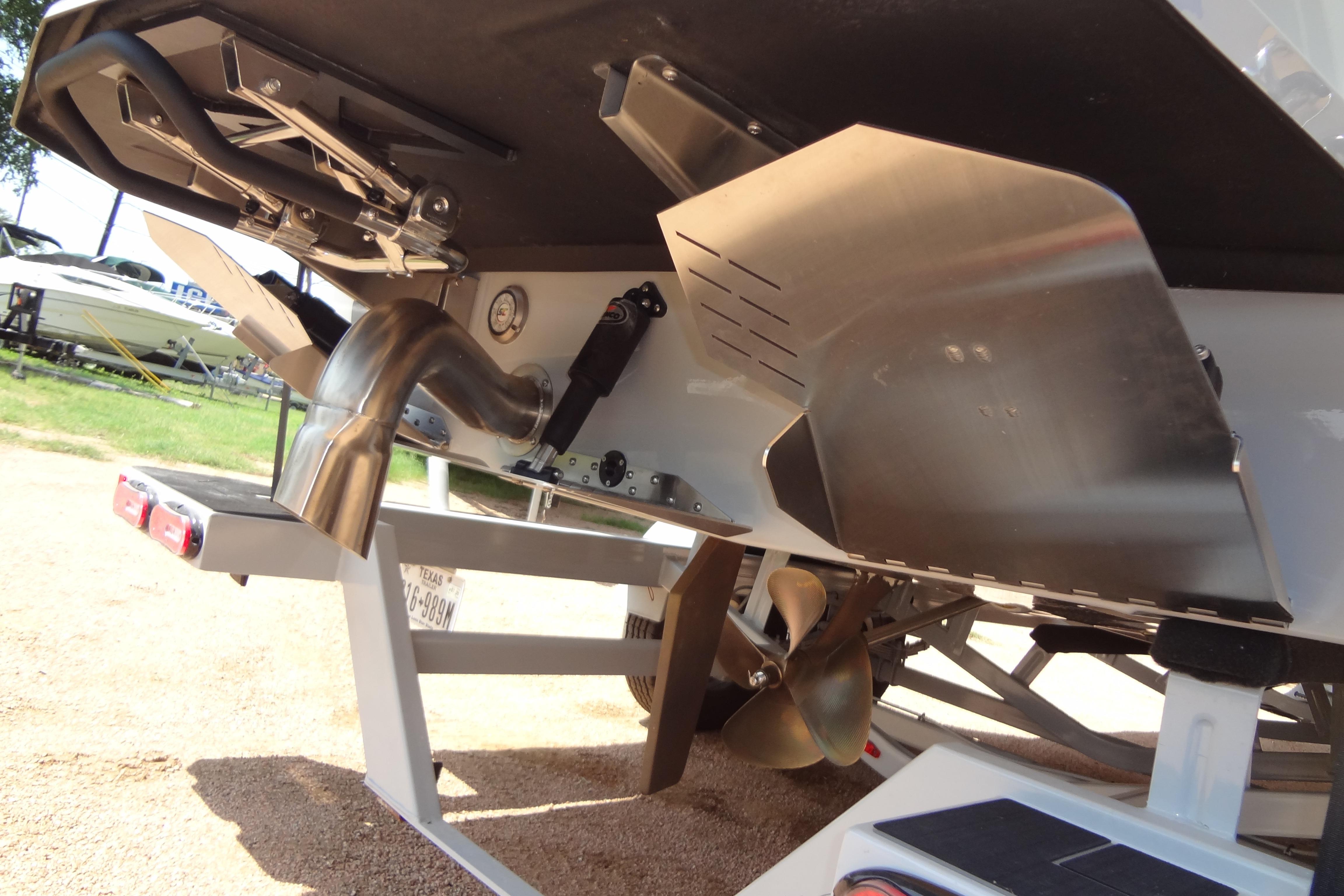 Rear view of 2022 ATX Surf Boats 24 Type-S, showcasing propeller and exhaust system.