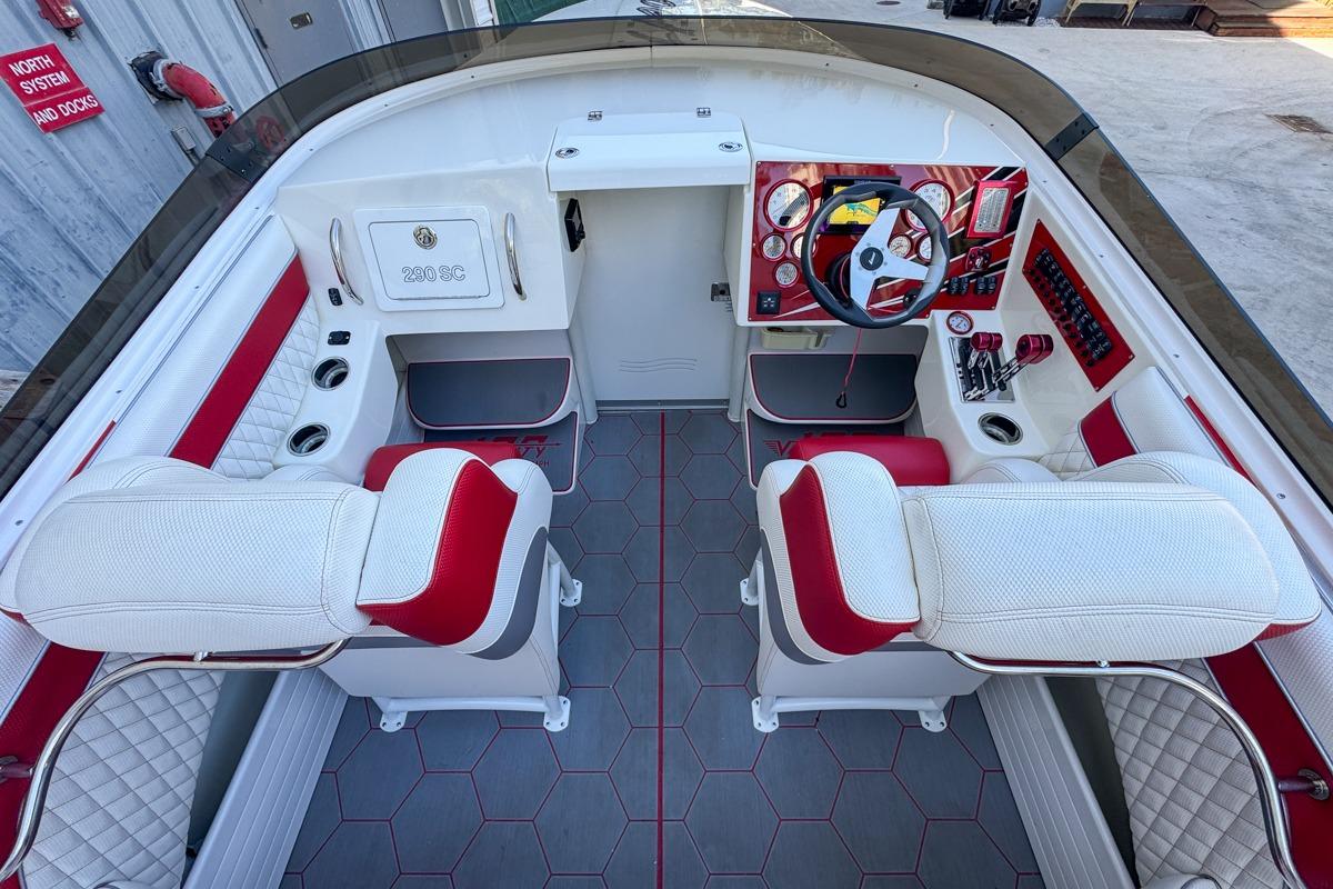 2022 Velocity 290sc boat interior with red and white seating, modern dashboard, and steering wheel.