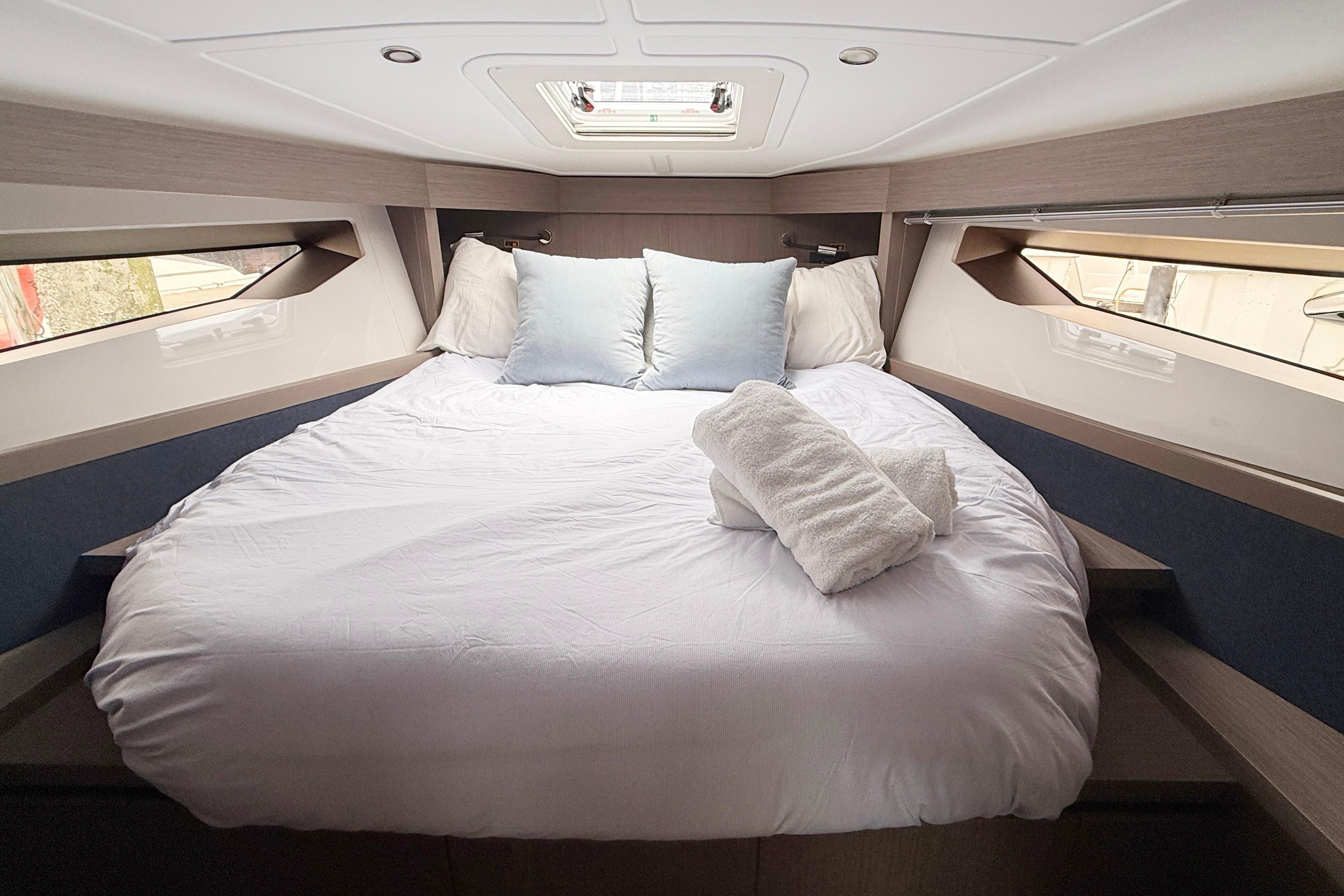 Luxurious cabin interior of 2022 Beneteau Gran Turismo 41 yacht with cozy bedding.