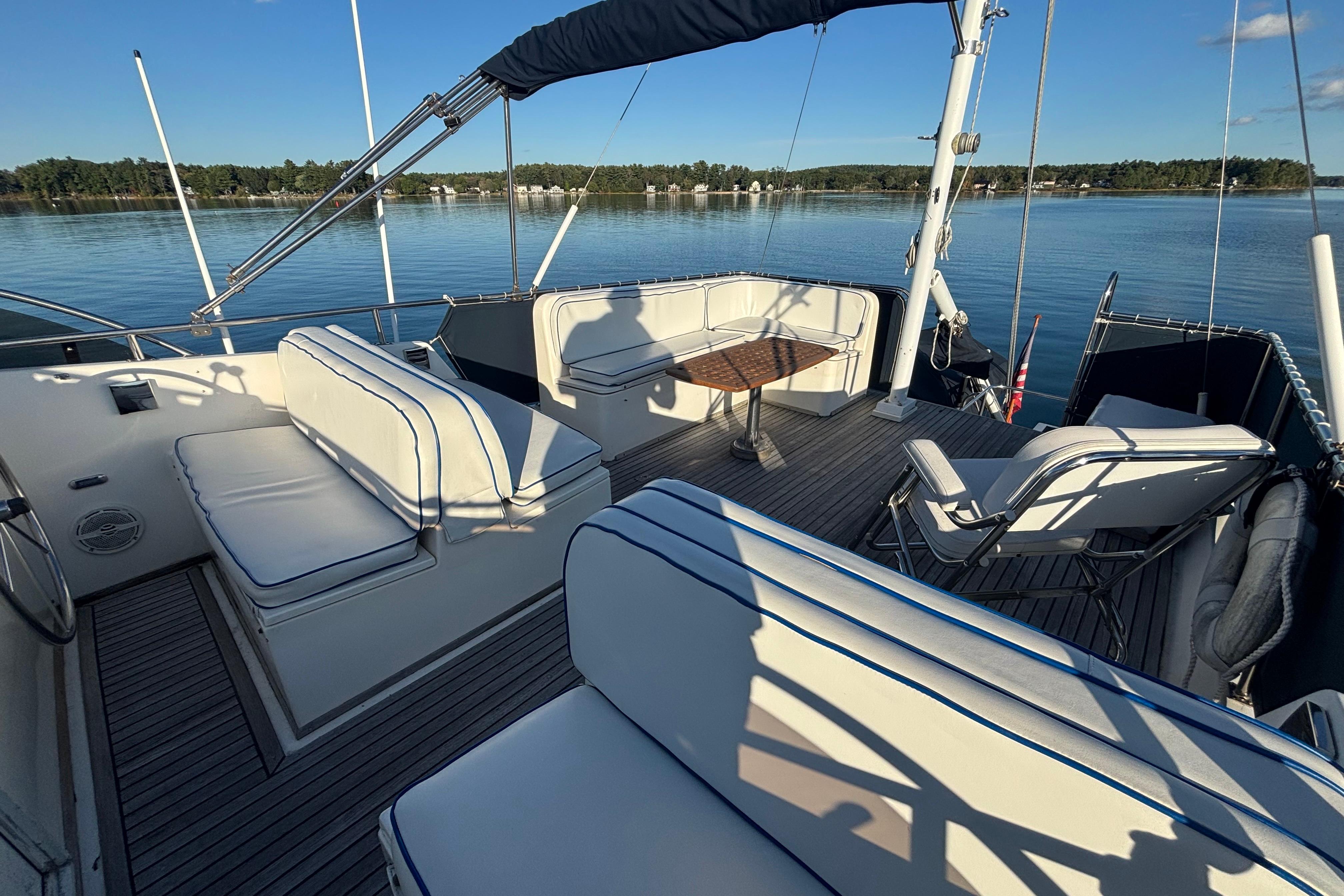 1989 Grand Banks 46 Classic yacht deck with seating and table, overlooking calm waters.