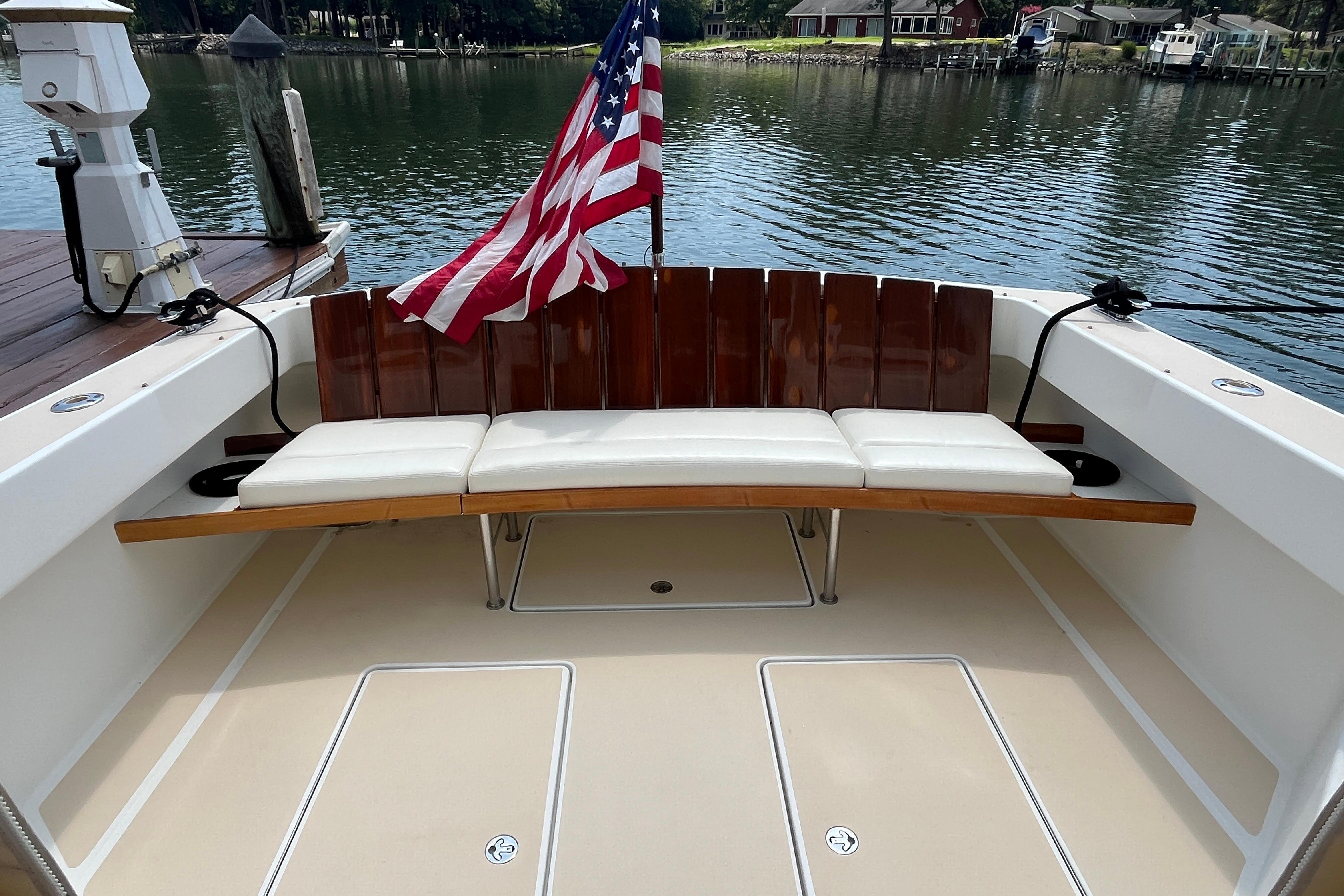 2006 MJM 34z boat with American flag and cushioned seating on deck.