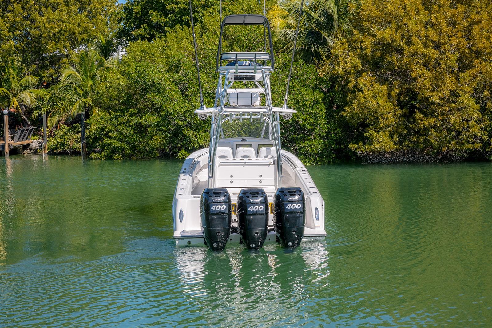 2022 Contender 39 Fisharound boat with triple 400 horsepower engines in a lush, tropical setting.