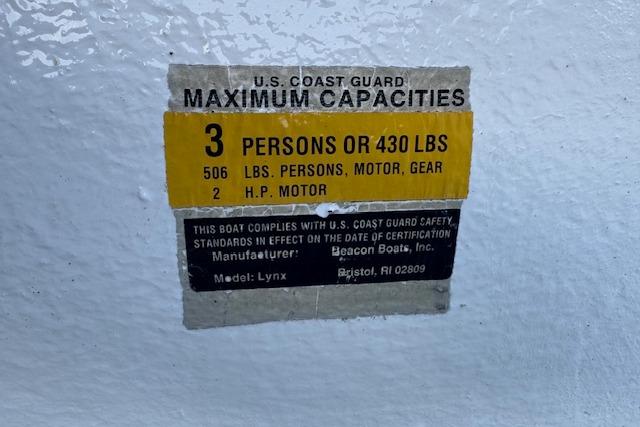 U.S. Coast Guard capacity label on 1999 Beacon Boats Pram, model Lynx, showing weight limits.