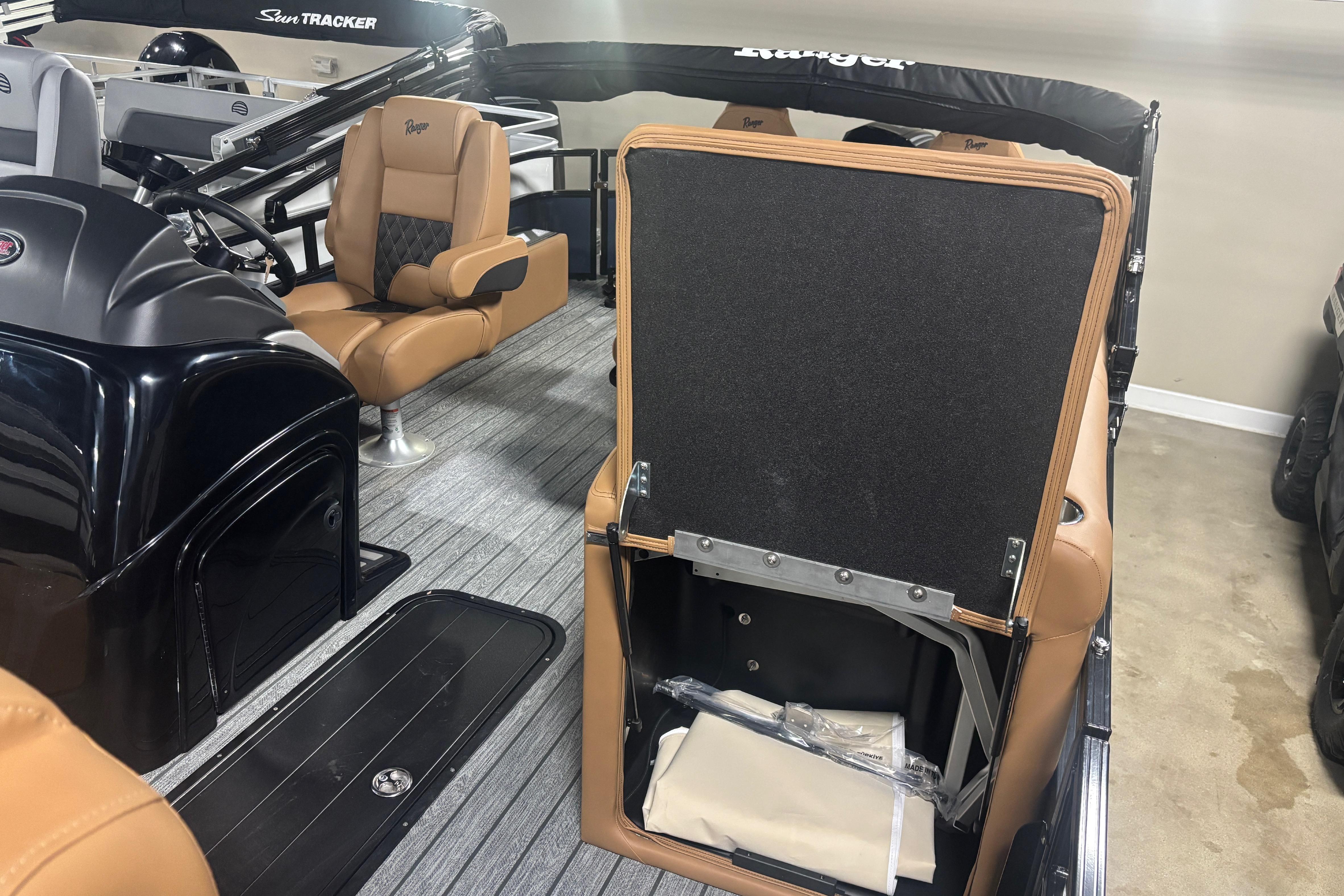 2026 Ranger 223F boat interior with tan seating and storage compartment open.