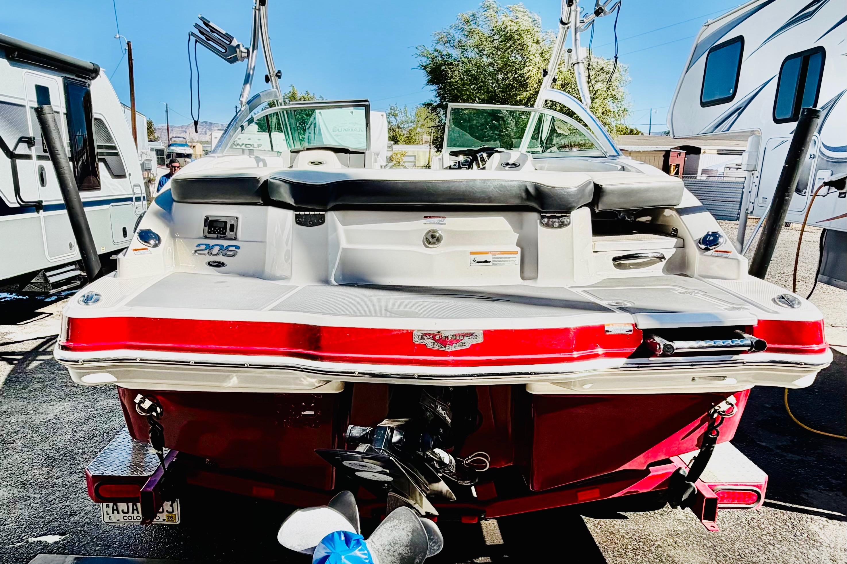 2013 Chaparral 206 SSi boat, rear view, parked between RVs.