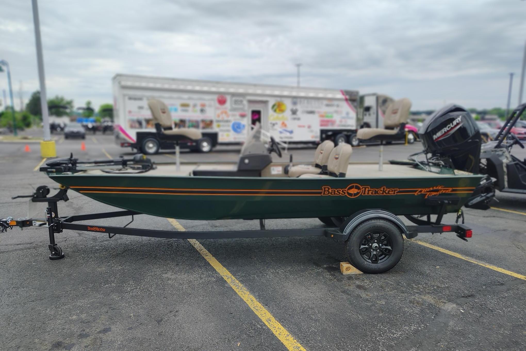 2026 Tracker Bass Tracker Classic Limited boat on trailer in parking lot.
