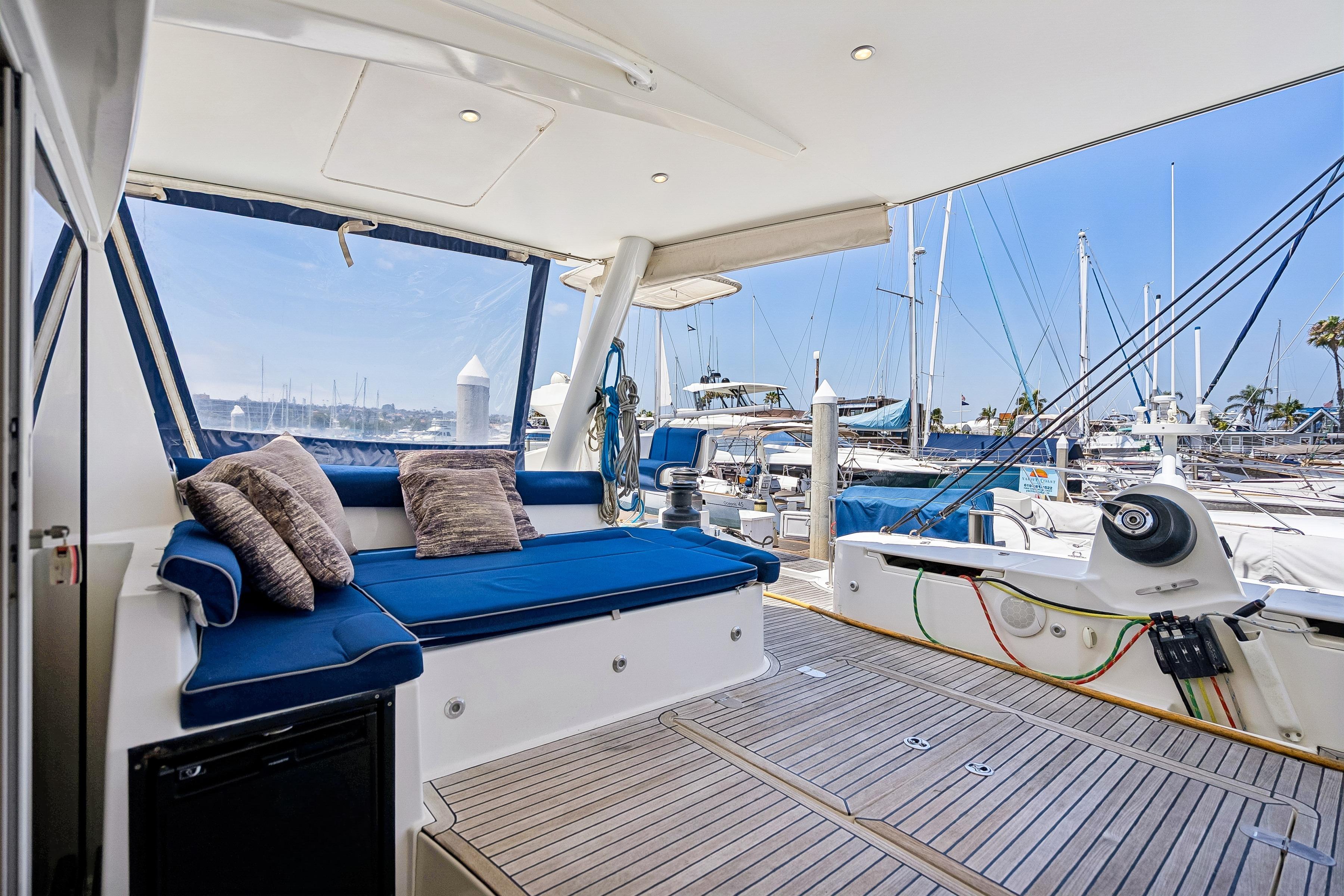 Luxurious 2009 Catana 65 yacht interior with plush seating and marina view.