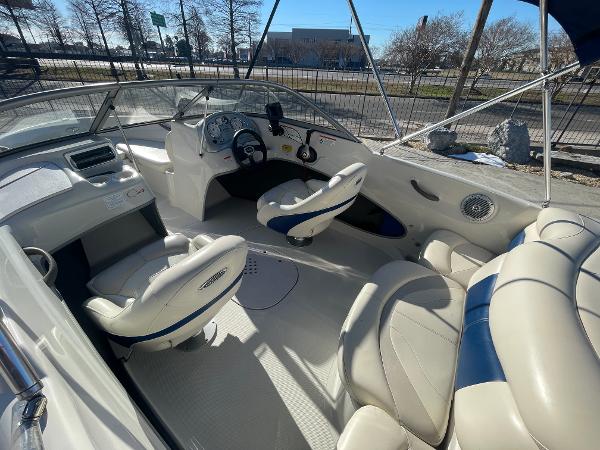 2012 Tahoe Q4 SS boat interior with white and blue seating, steering wheel, and dashboard.