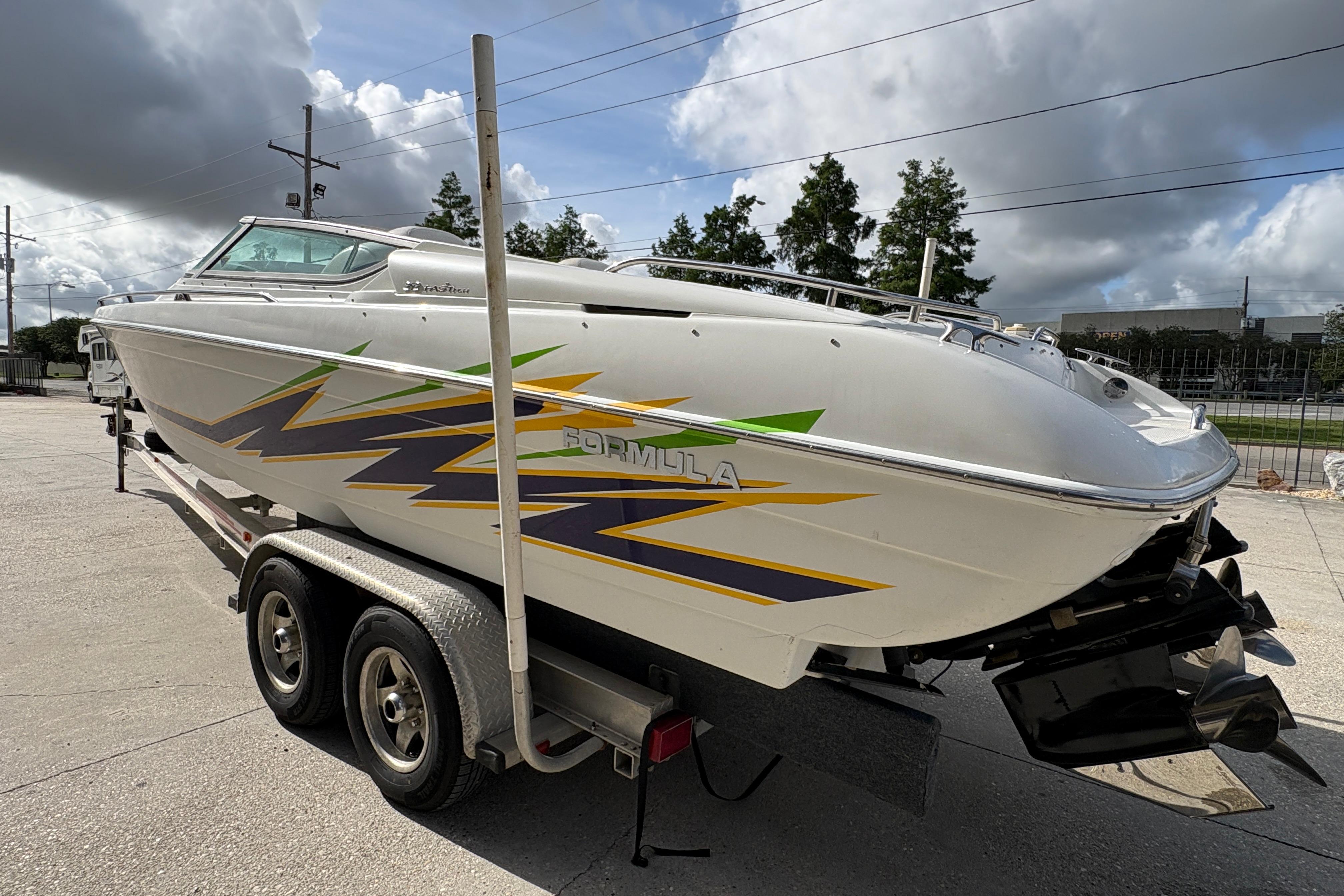 2002 Formula 292 FASTech boat on trailer, featuring vibrant graphics, parked outdoors.