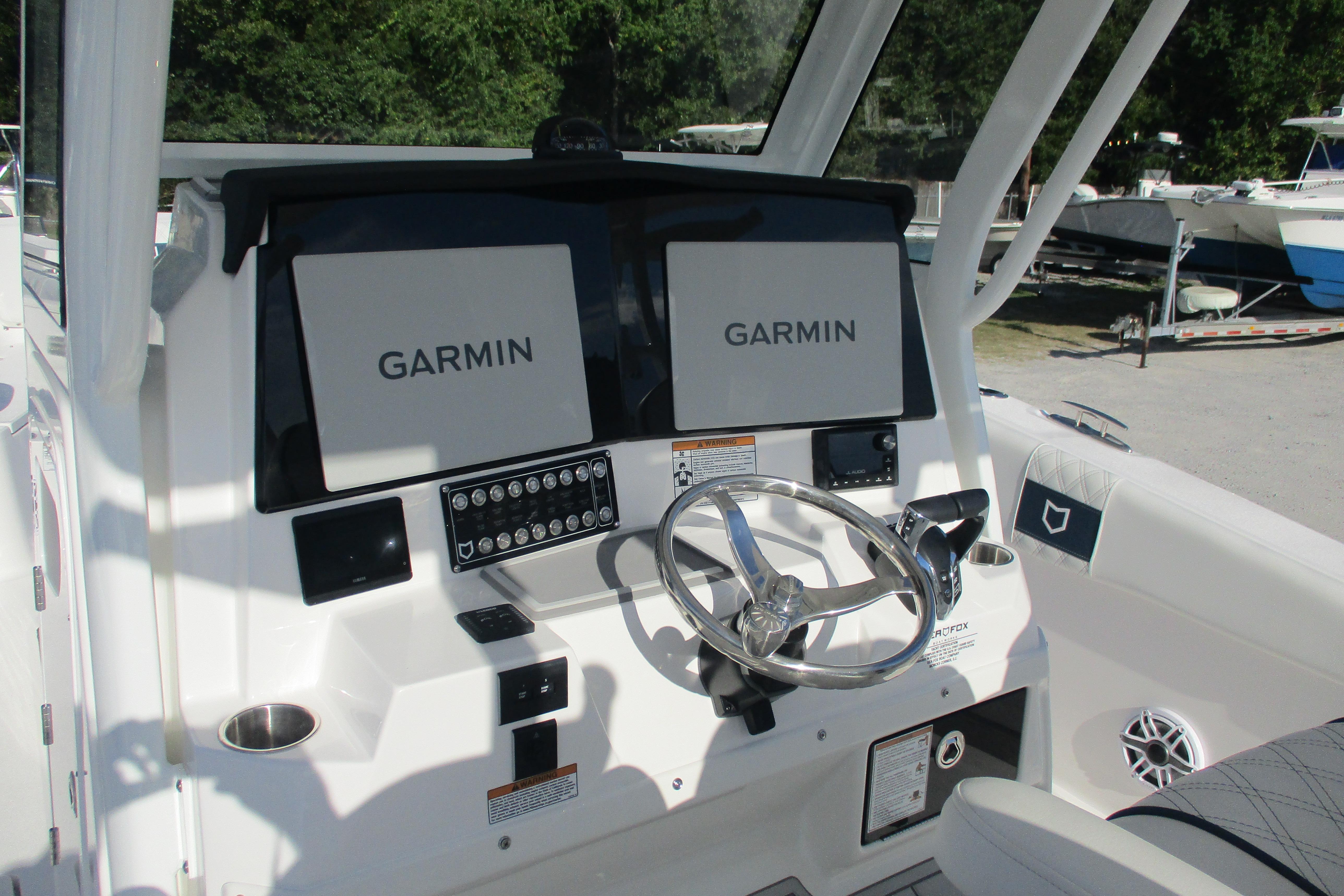 2026 Sea Fox 328 Commander helm with dual Garmin displays and stainless steel steering wheel.
