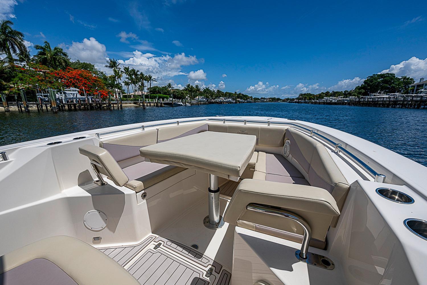 2019 Cobia 320 Center Console boat with seating area on a sunny day.
